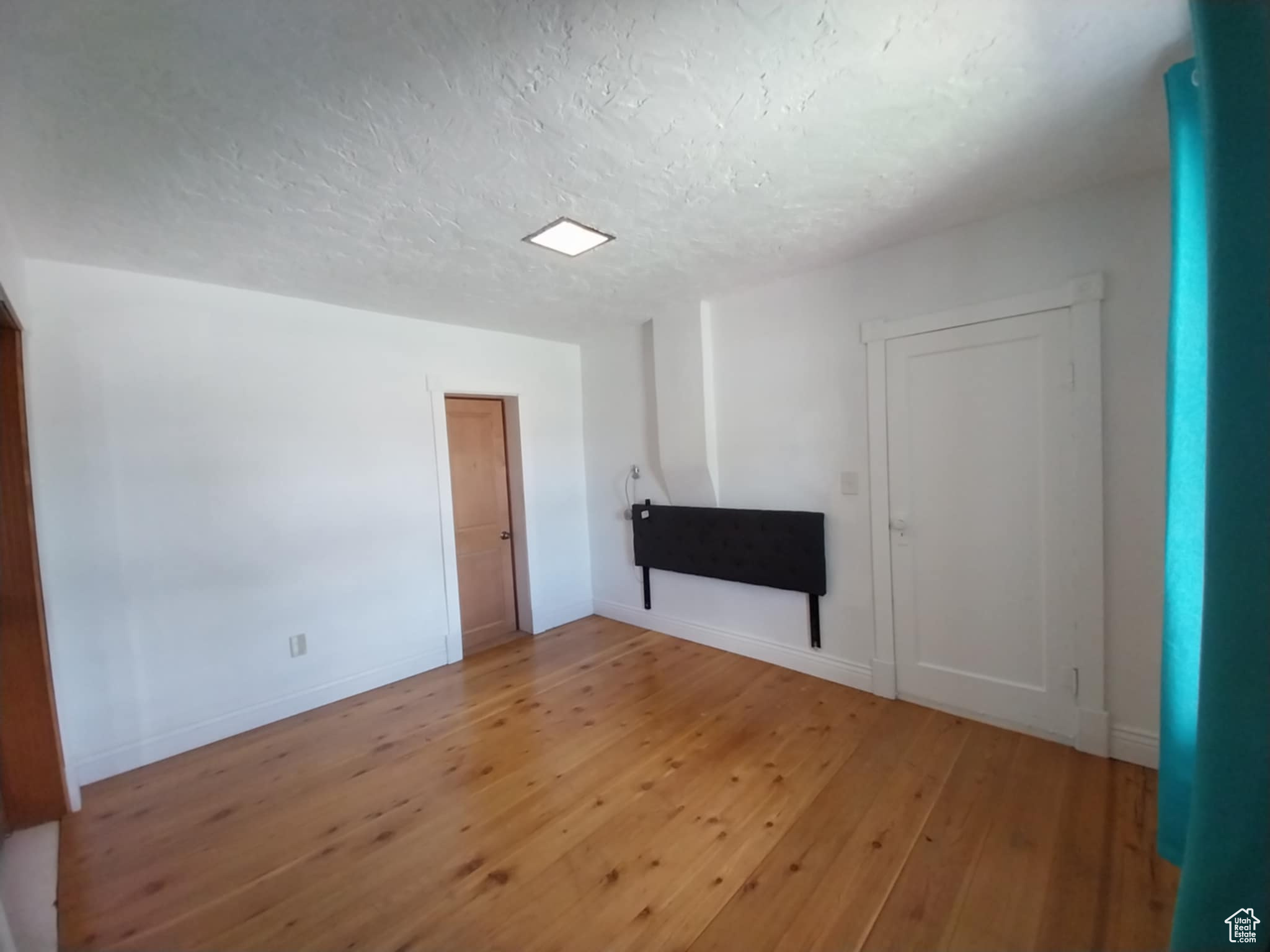 Spare room featuring hardwood / wood-style flooring and a textured ceiling