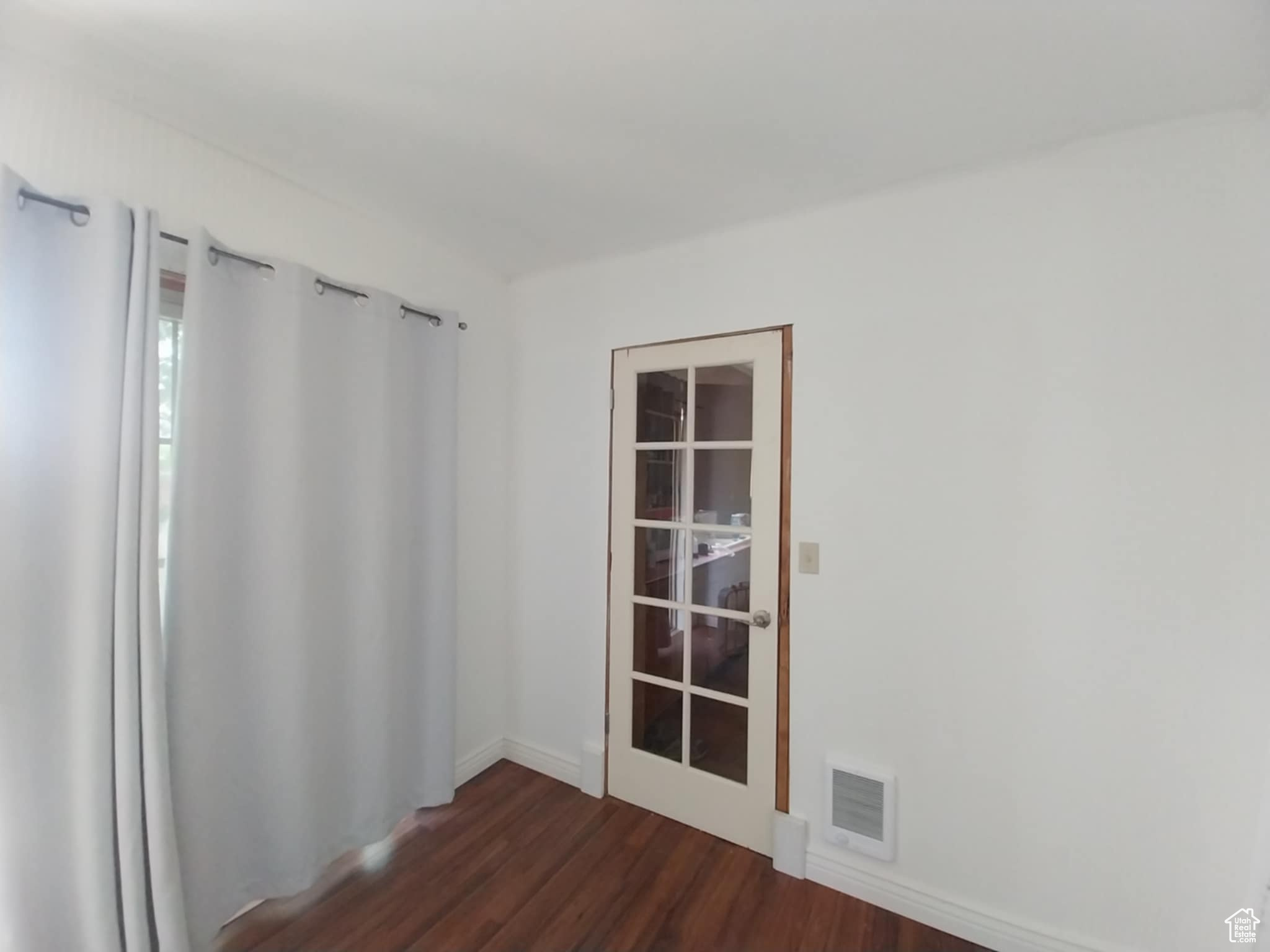 Empty room featuring dark hardwood / wood-style floors