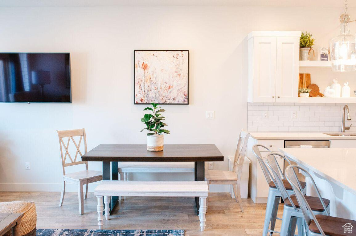Dining space with sink and light wood-type flooring