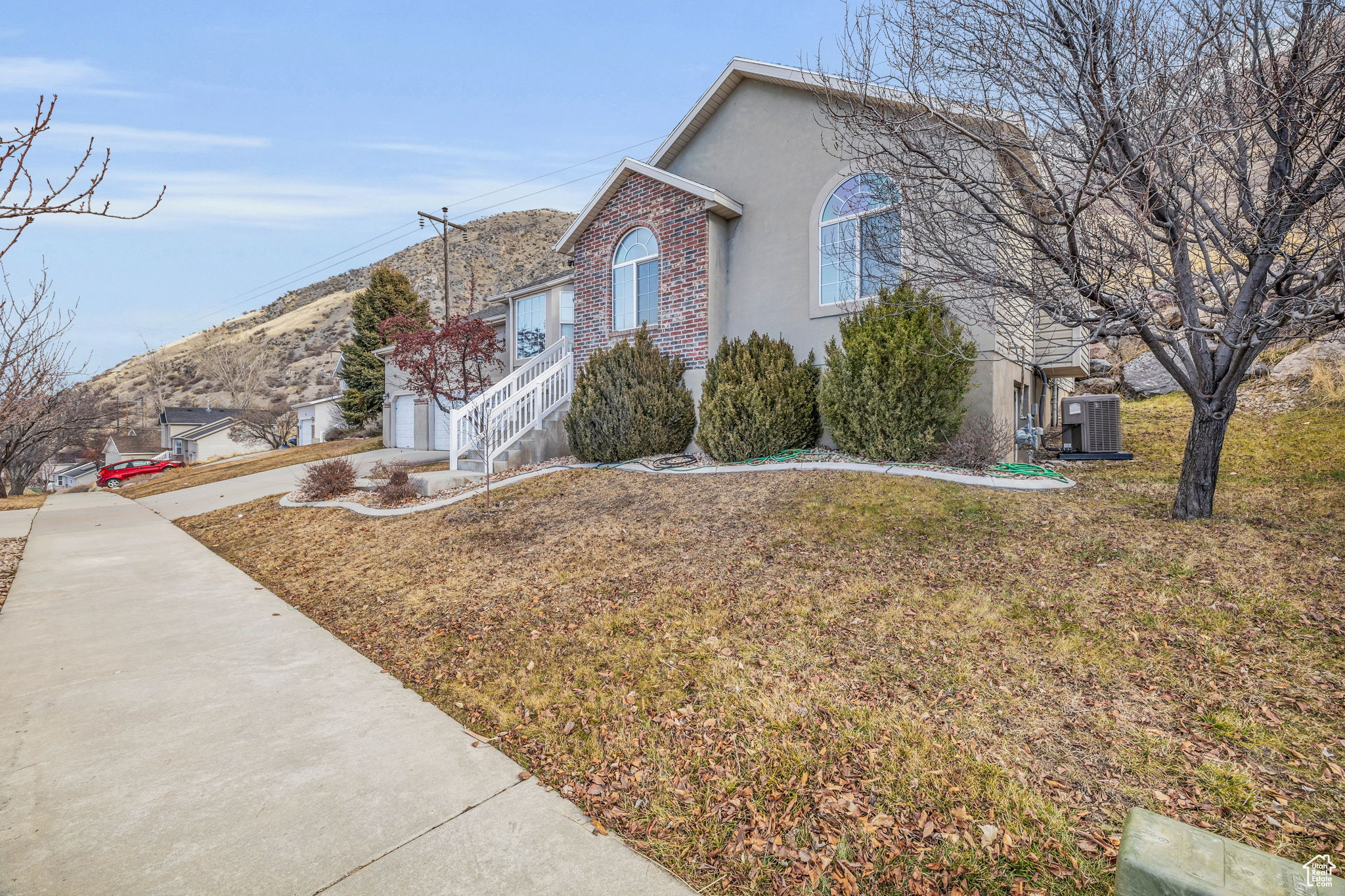 View of side of property with a garage, central AC, and a lawn