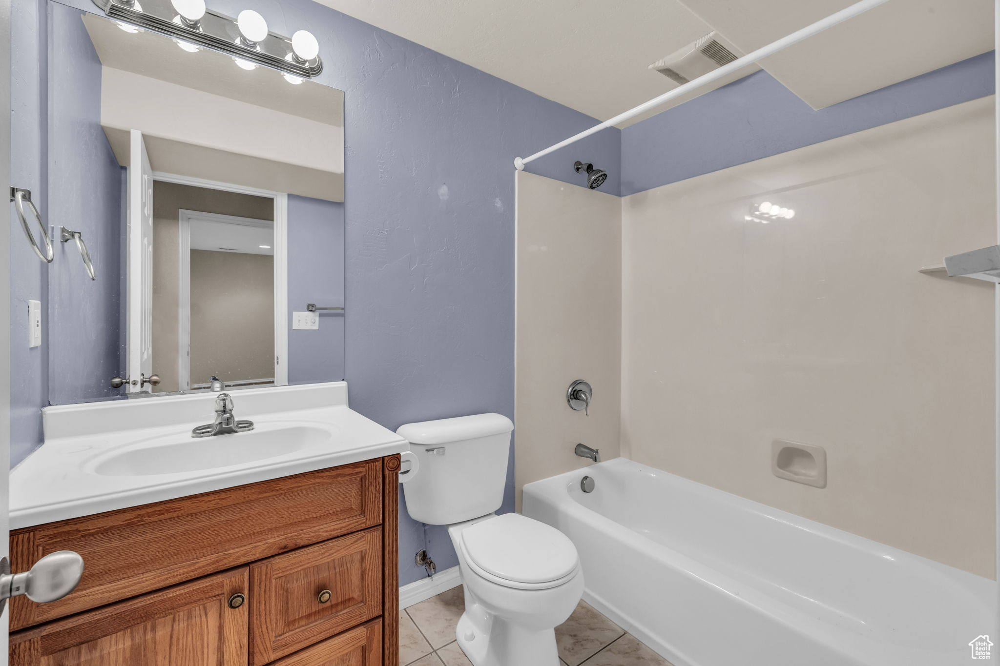 Full bathroom featuring shower / bath combination, vanity, tile patterned floors, and toilet