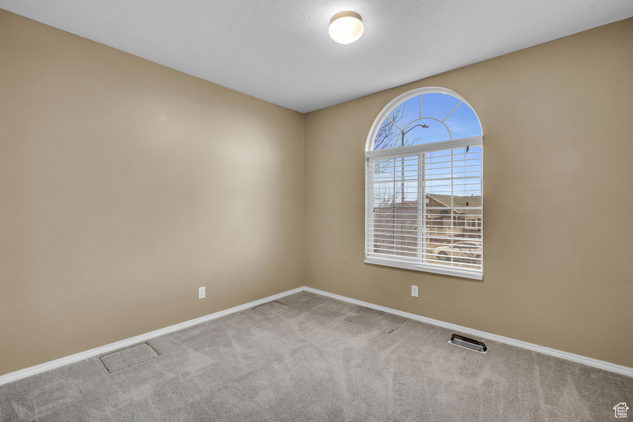 Empty room with light colored carpet