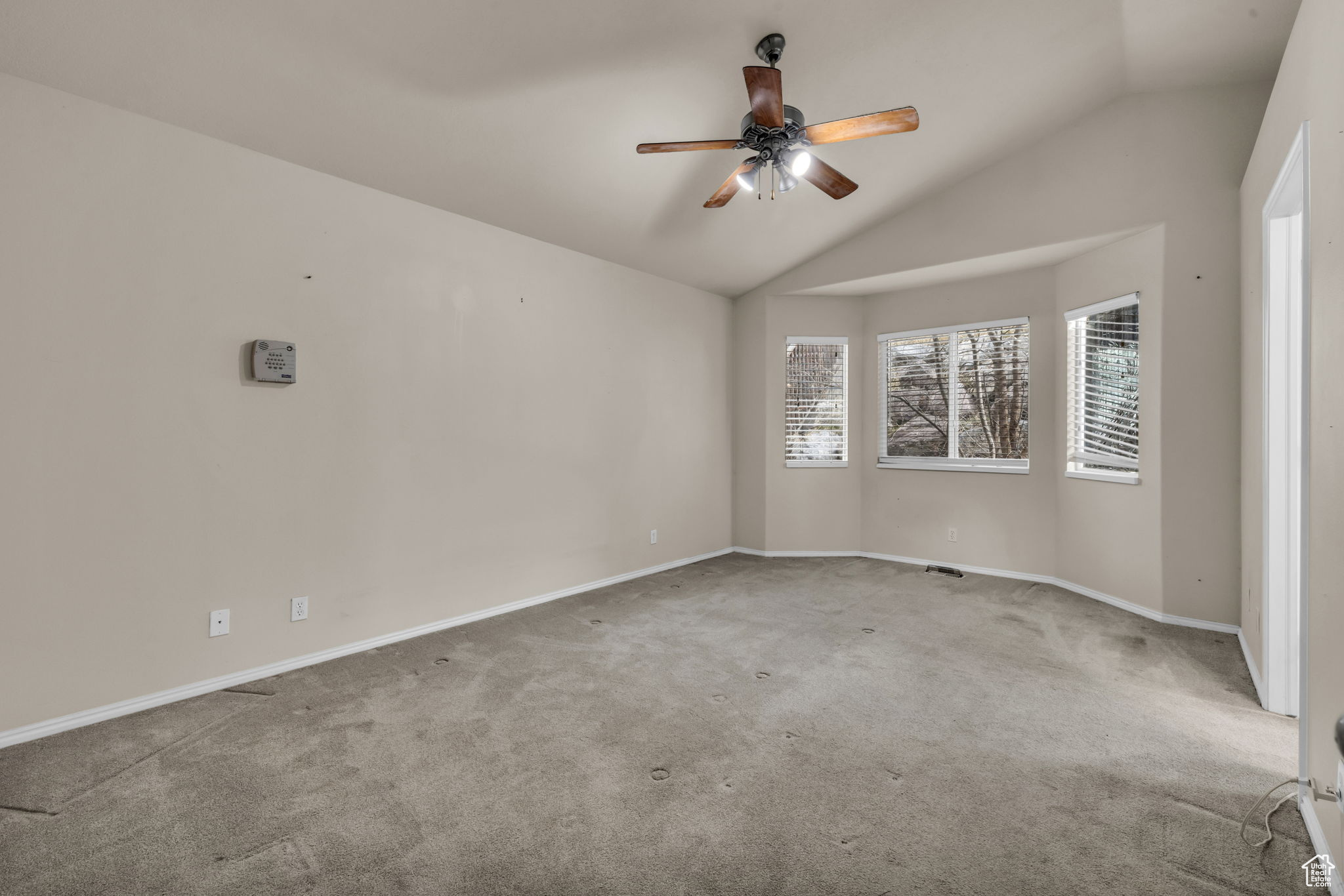 Spare room with ceiling fan, lofted ceiling, and carpet floors