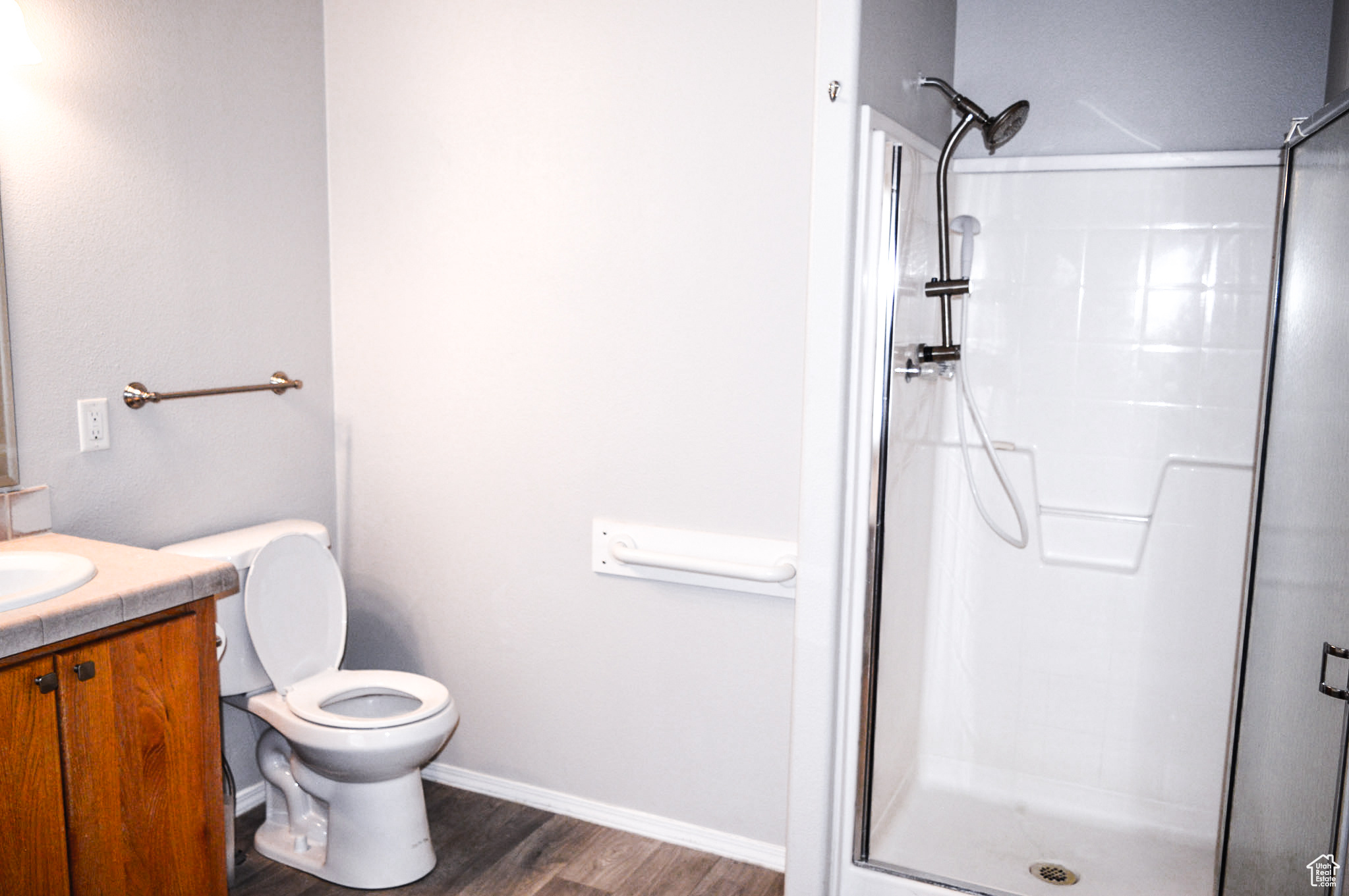 Bathroom featuring grab bar by toilet and  walk in shower