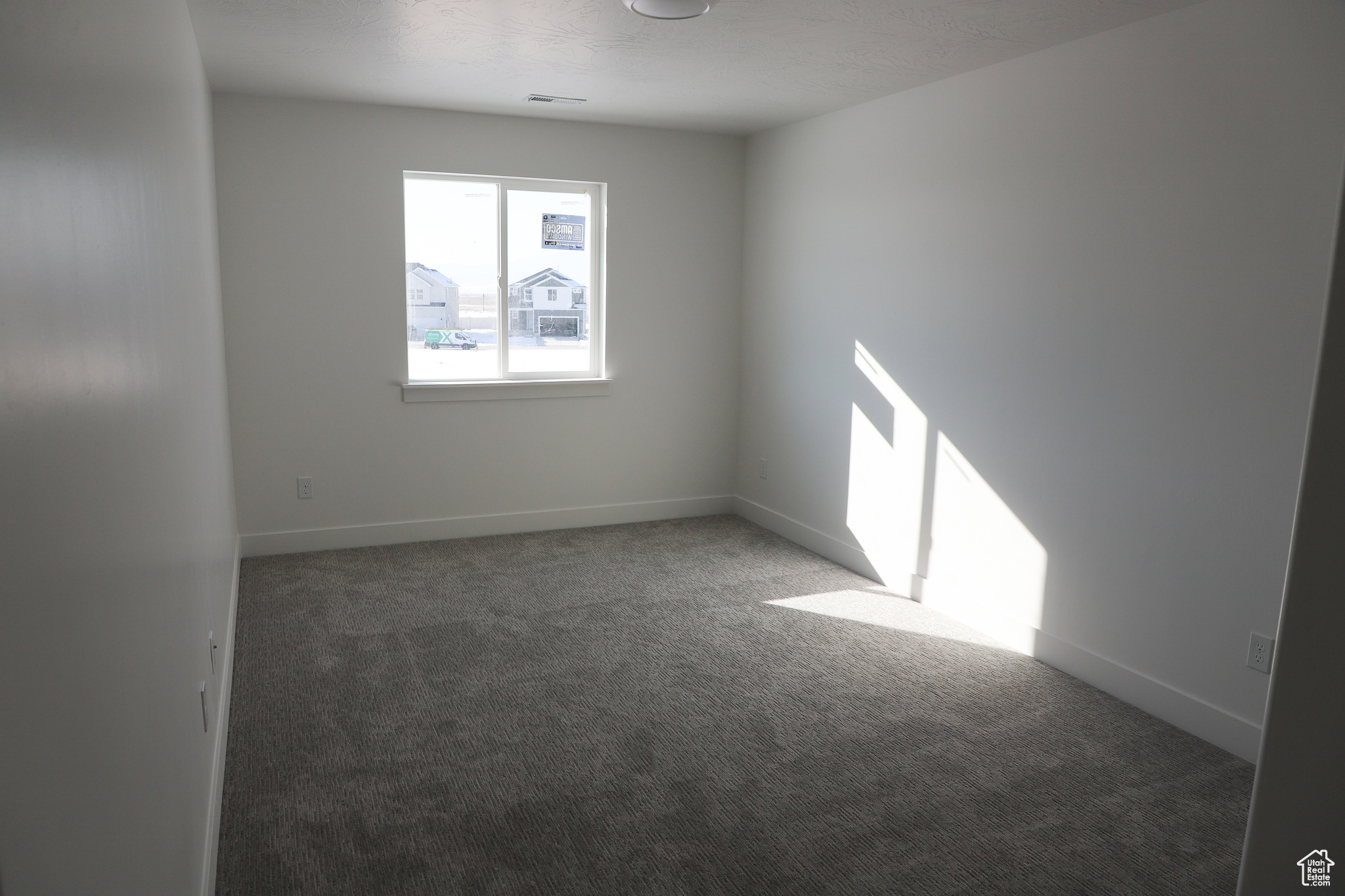 Spare room featuring dark colored carpet