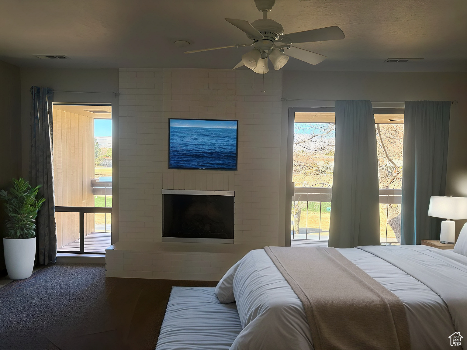 Bedroom featuring hardwood / wood-style flooring, a fireplace, and ceiling fan