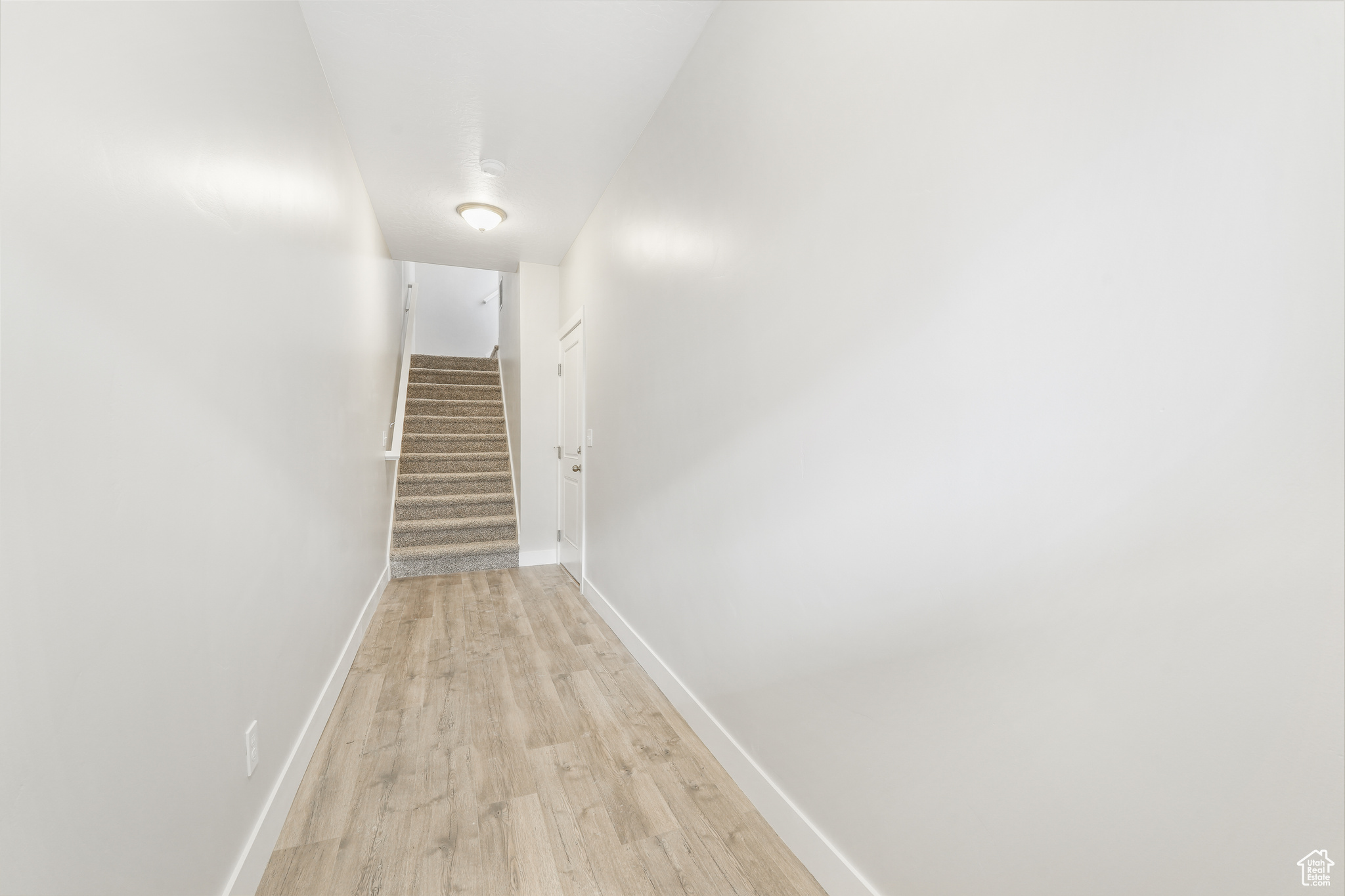 Corridor with light hardwood / wood-style flooring