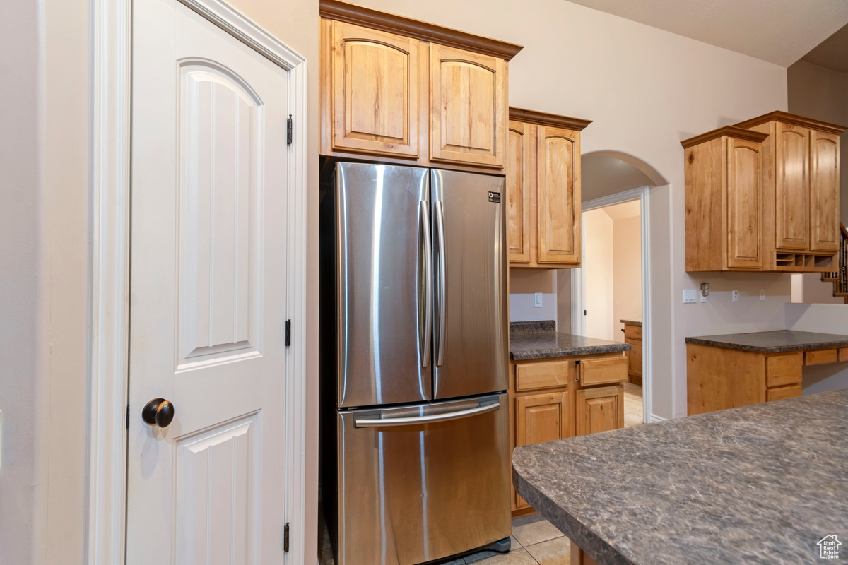Kitchen featuring stainless steel fridge and light tile patterned flooring
