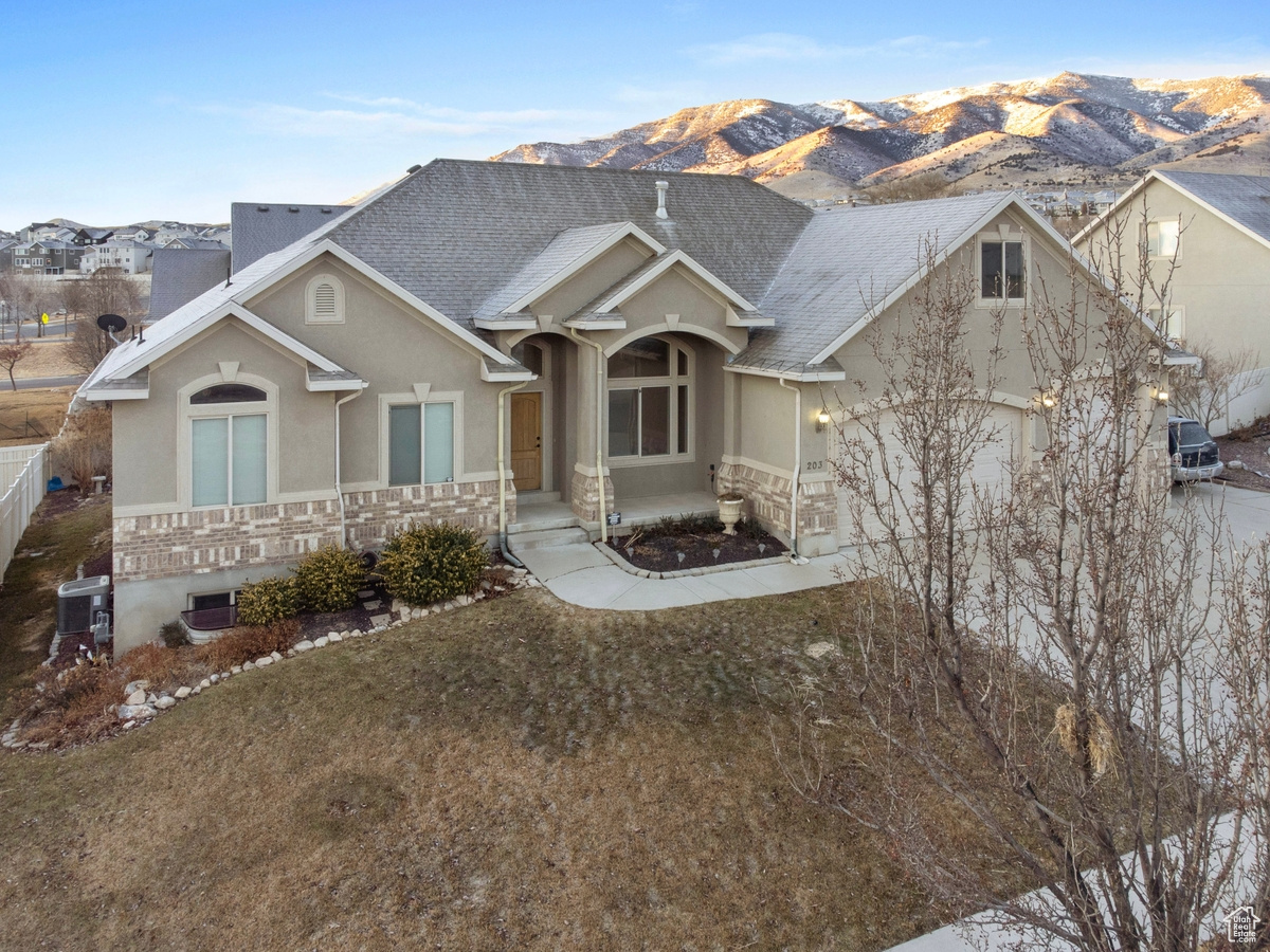 View of front facade featuring a mountain view, central AC, and a front yard
