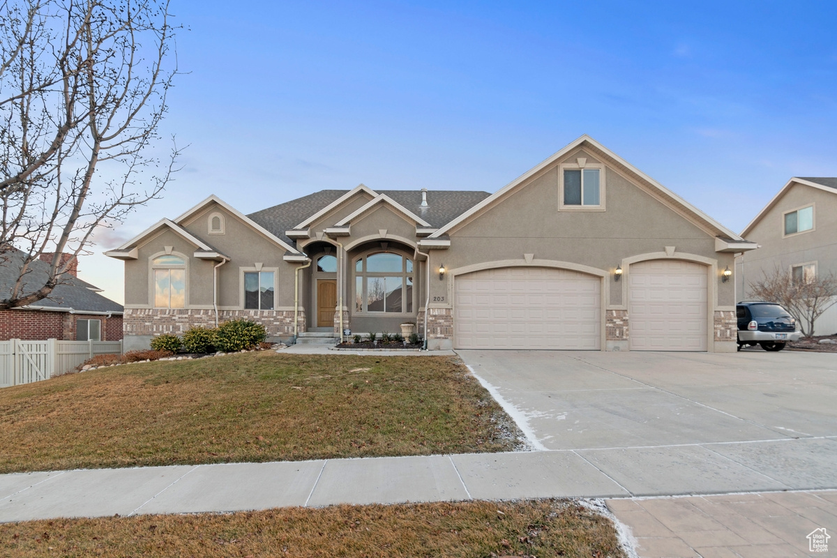 View of front facade featuring a garage and a front yard