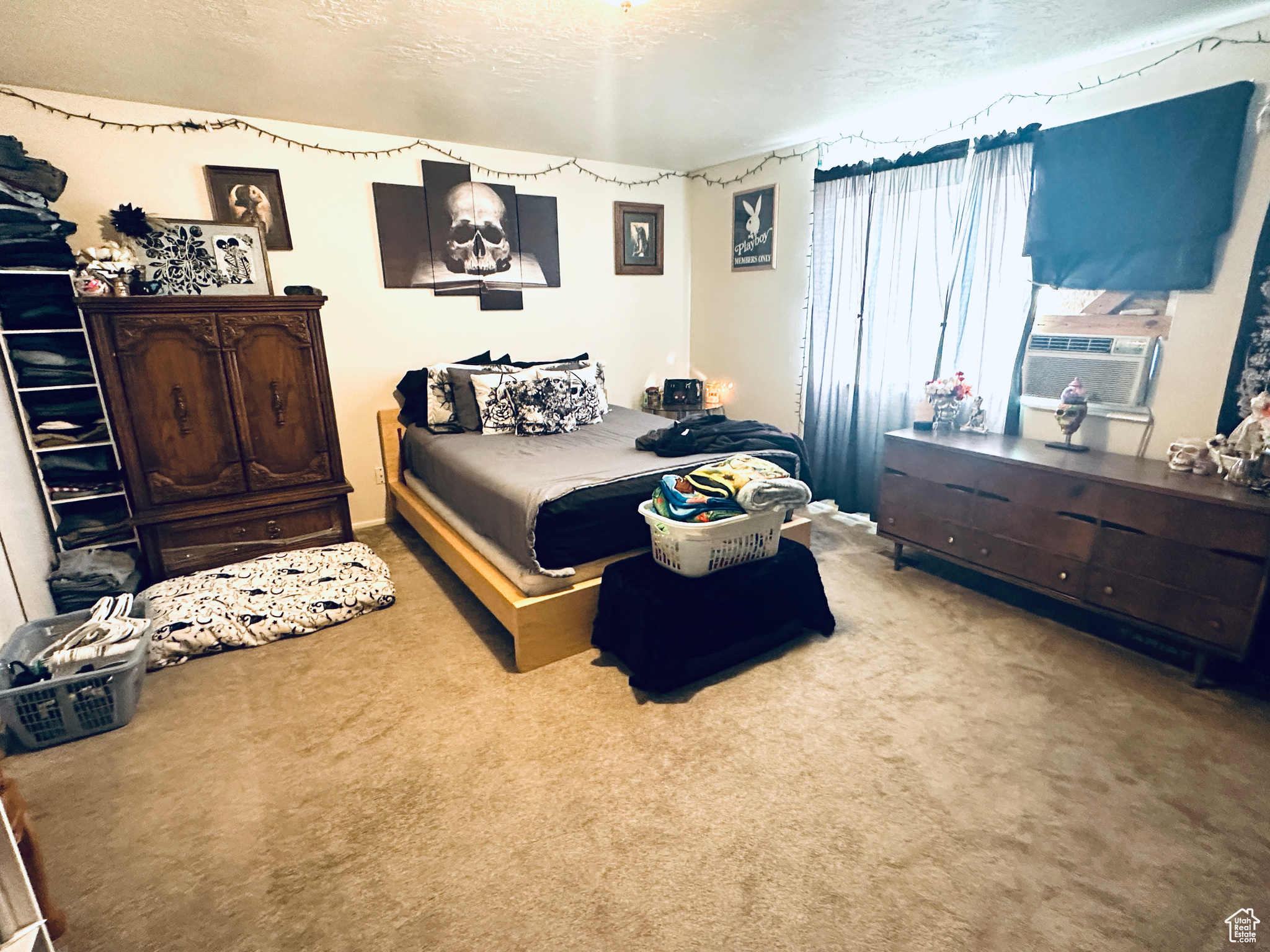 Carpeted bedroom with cooling unit and a textured ceiling