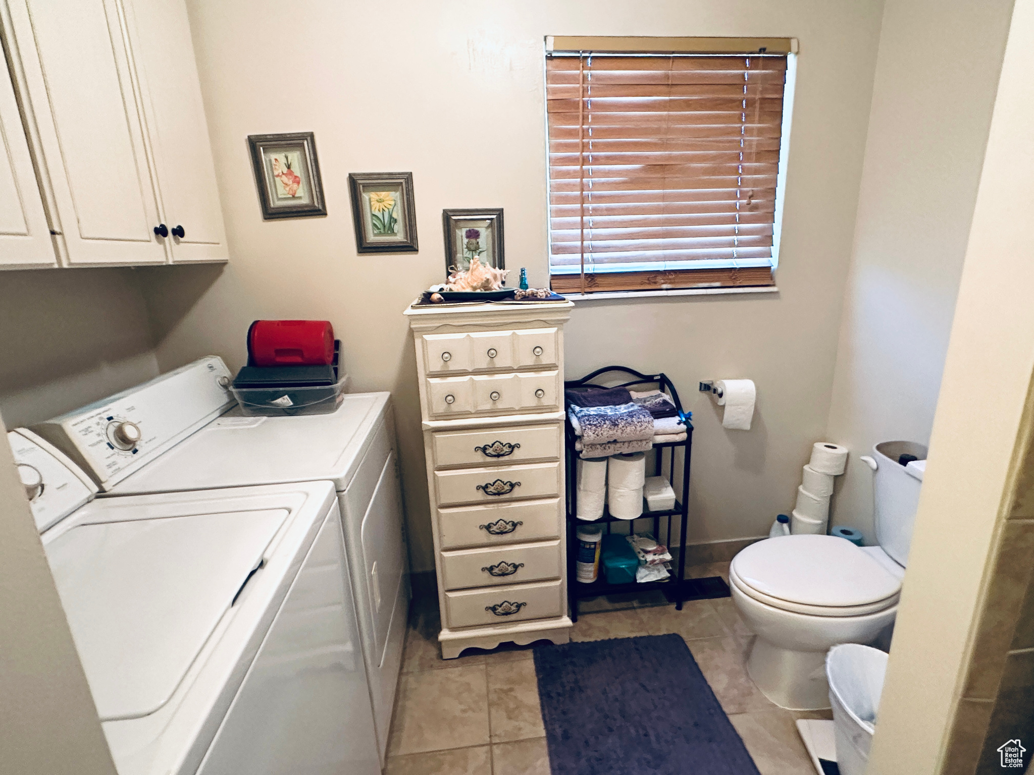 Laundry area featuring light tile patterned flooring and independent washer and dryer