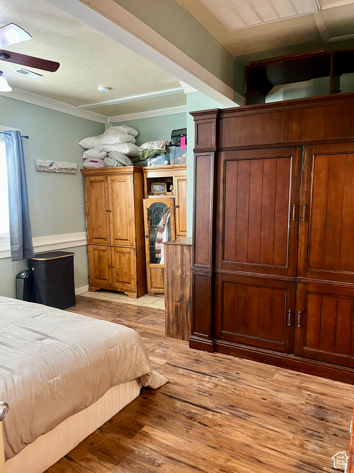 Bedroom with ornamental molding and light hardwood / wood-style flooring