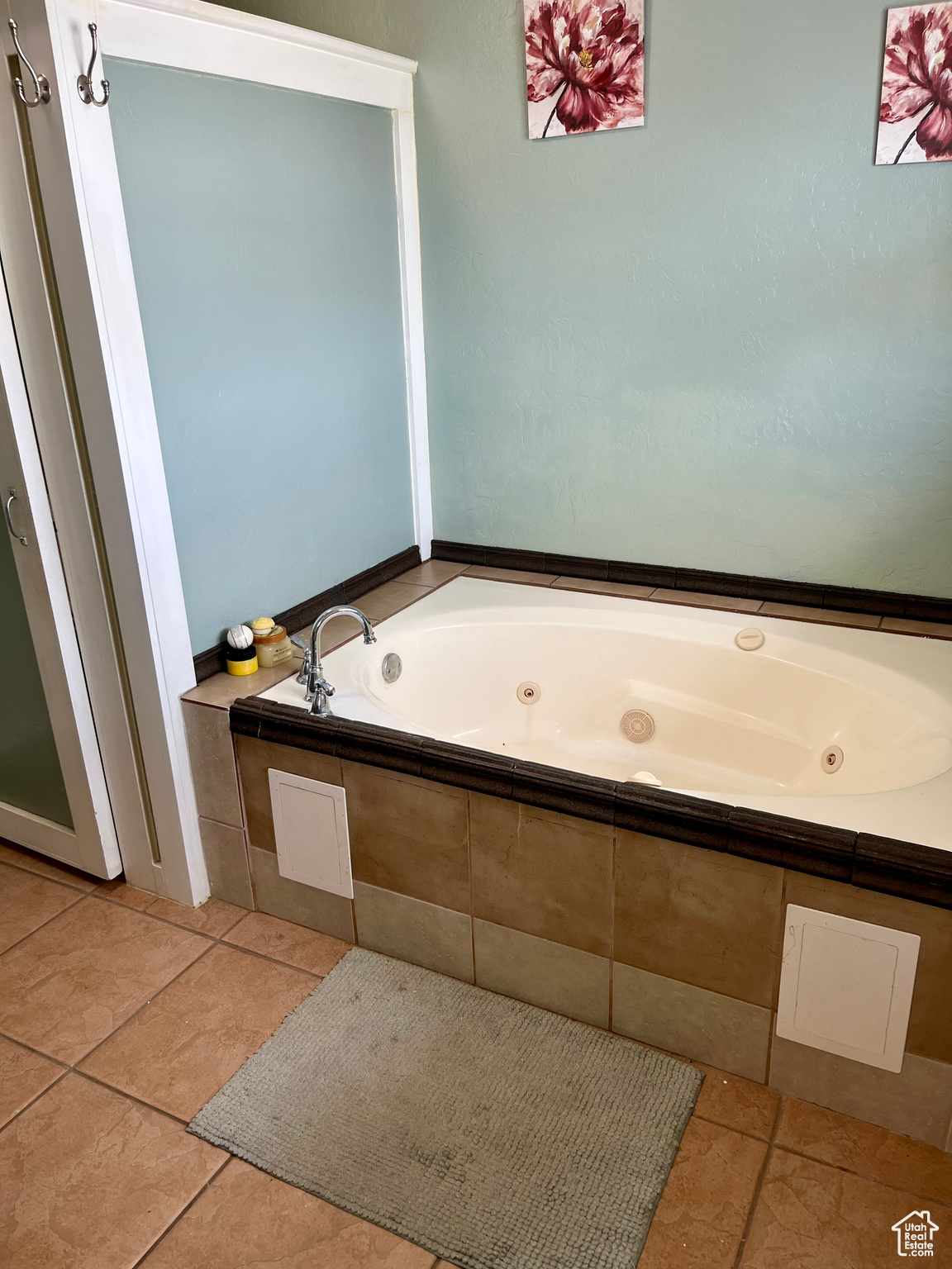 Bathroom with a relaxing tiled tub and tile patterned floors