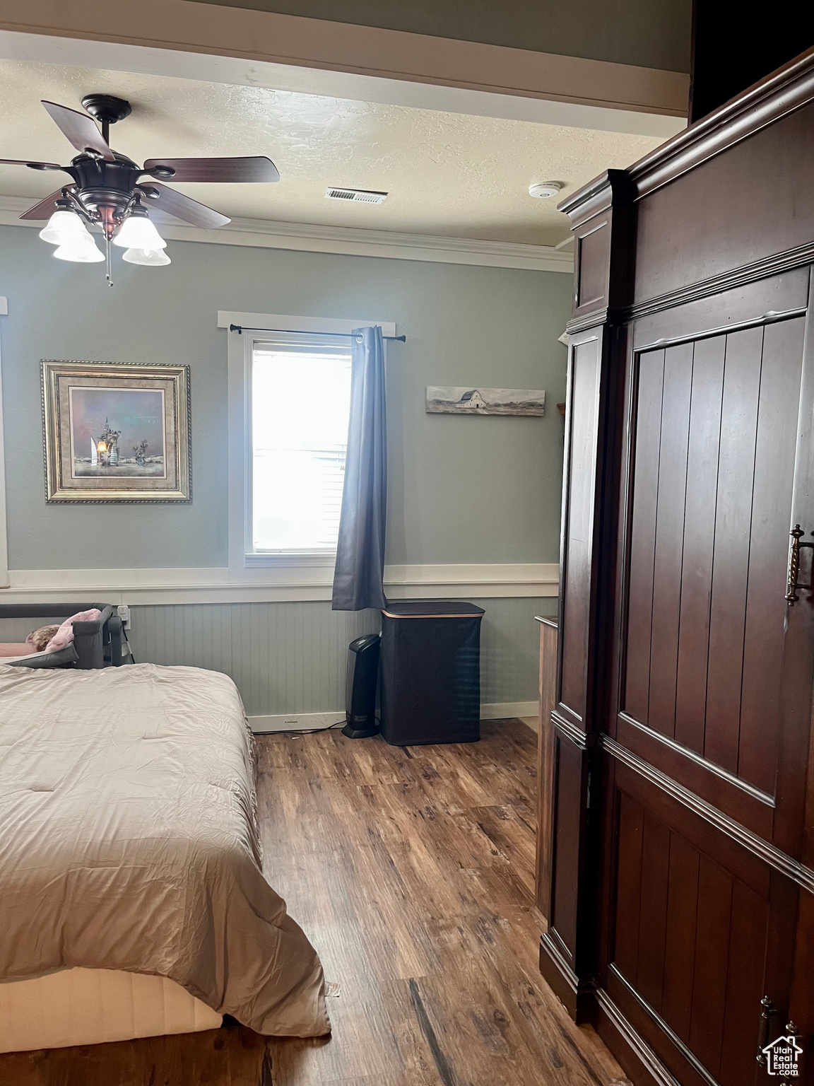 Bedroom with crown molding, a textured ceiling, radiator heating unit, ceiling fan, and hardwood / wood-style floors