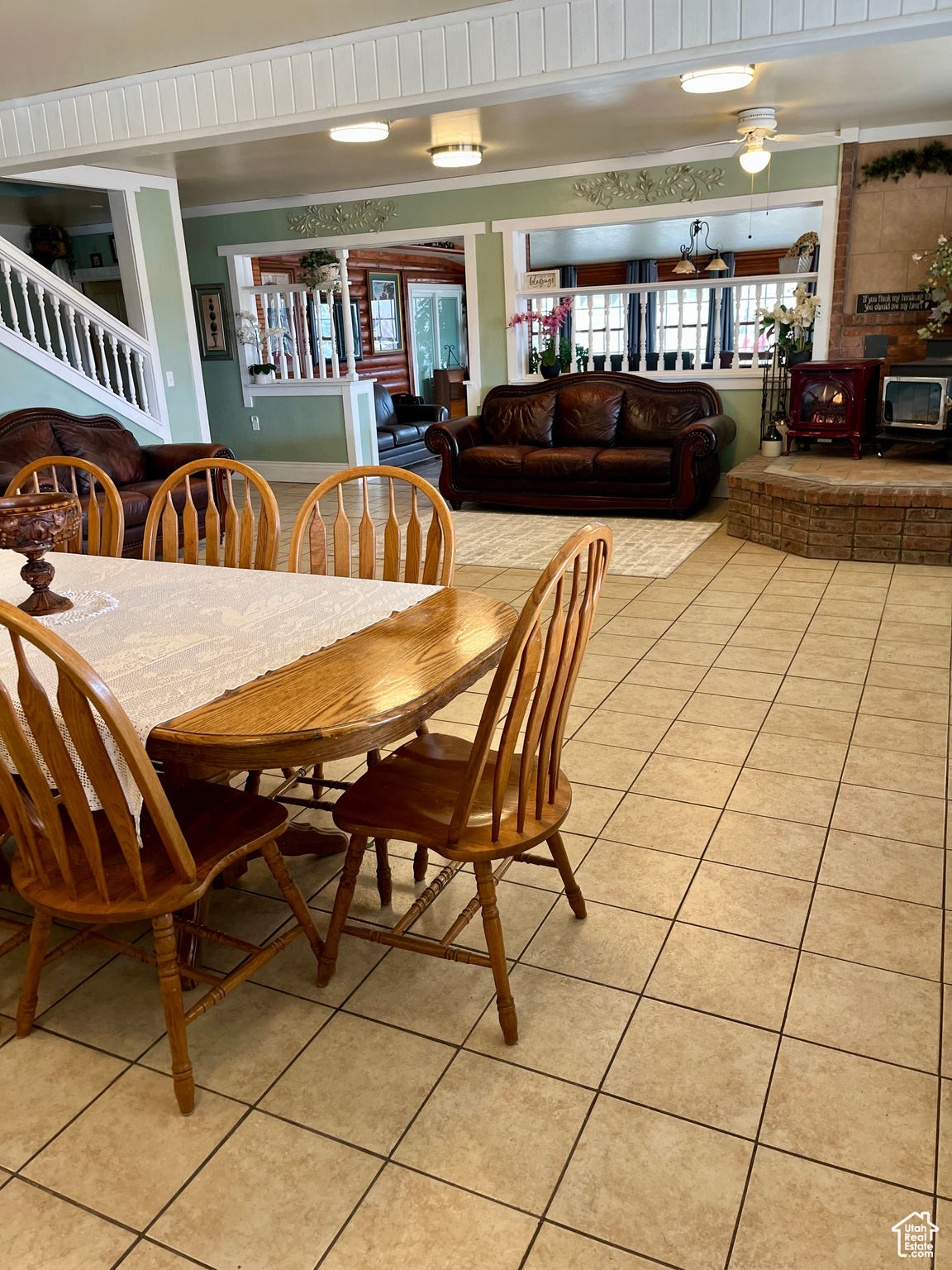 Dining room with light tile patterned flooring, crown molding, and a wood stove