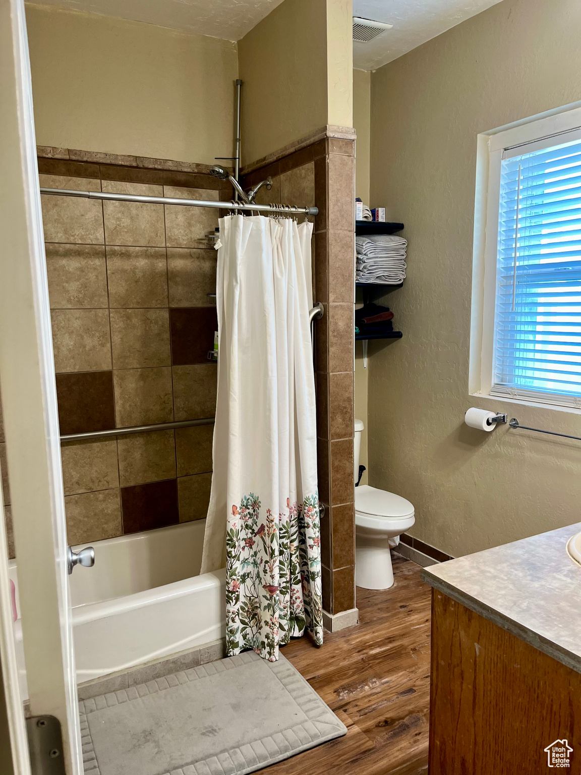 Full bathroom with shower / tub combo with curtain, wood-type flooring, toilet, and vanity