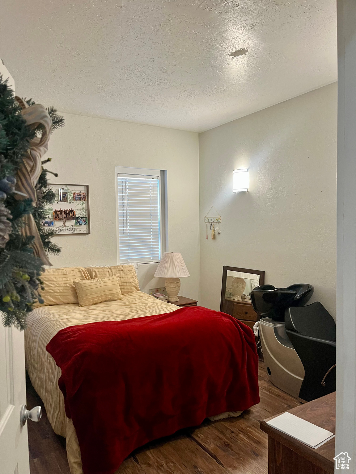 Bedroom with hardwood / wood-style floors and a textured ceiling