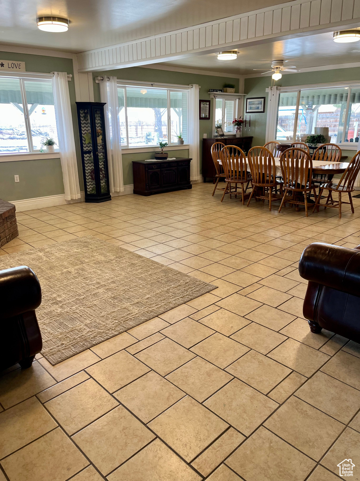 Living room featuring a wealth of natural light, ornamental molding, ceiling fan, and light tile patterned flooring