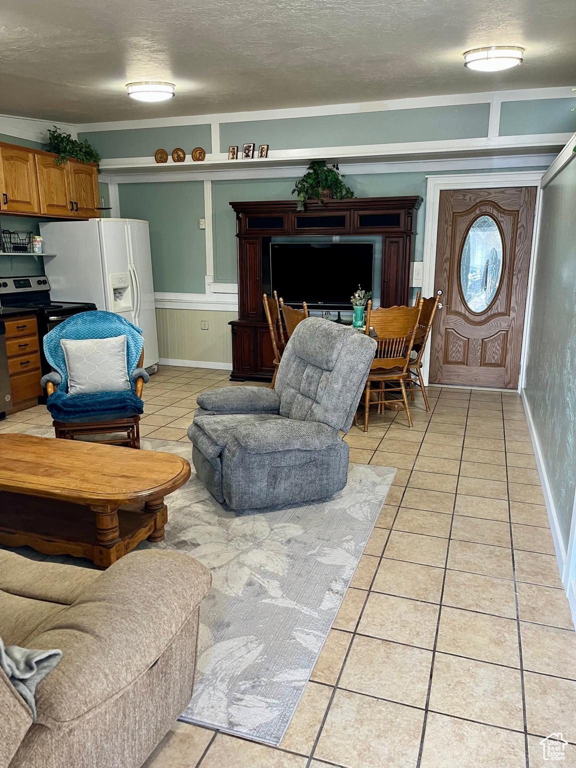 Living room with a textured ceiling and light tile patterned flooring