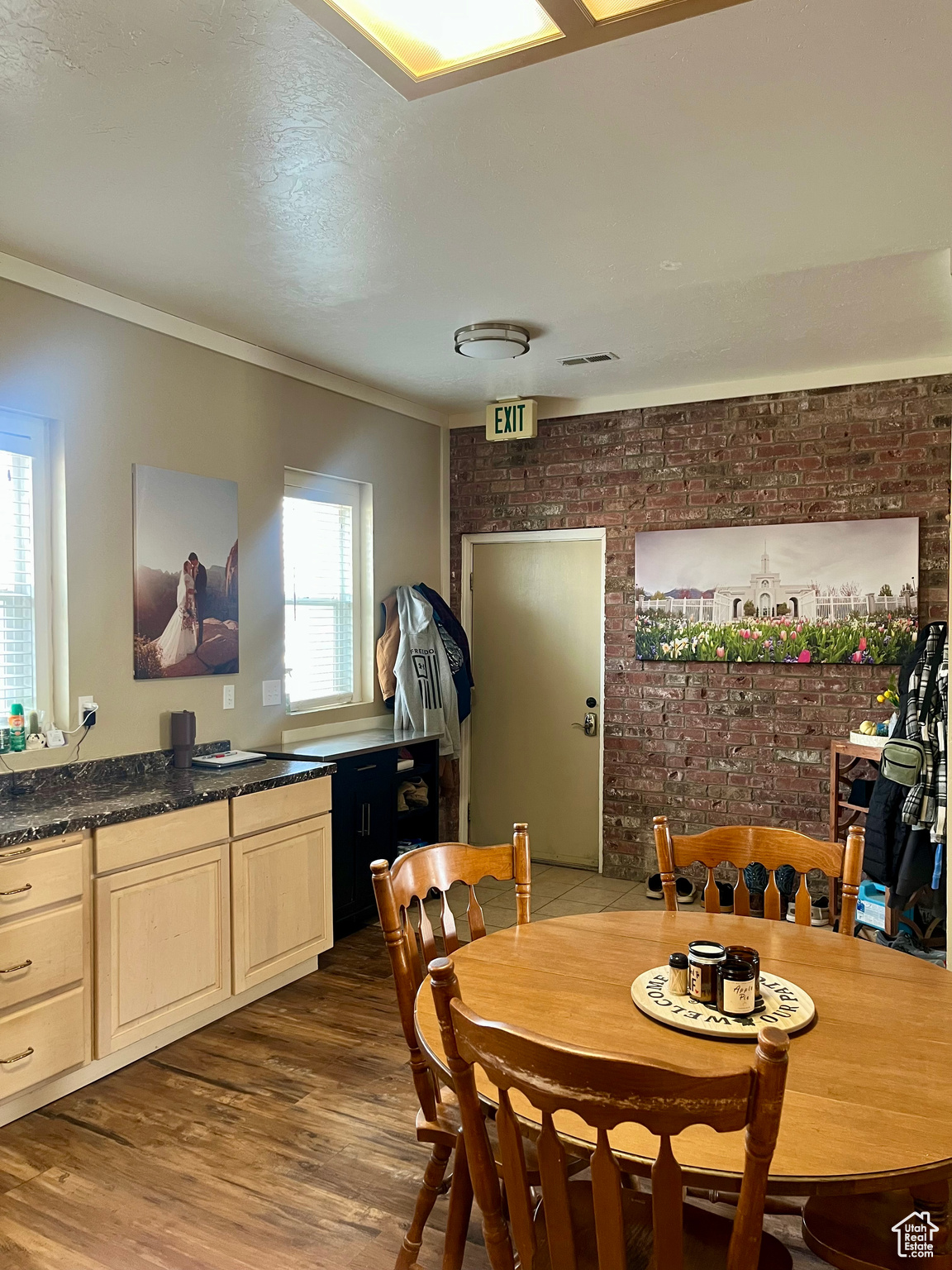 Dining area with crown molding, dark hardwood / wood-style floors, and brick wall