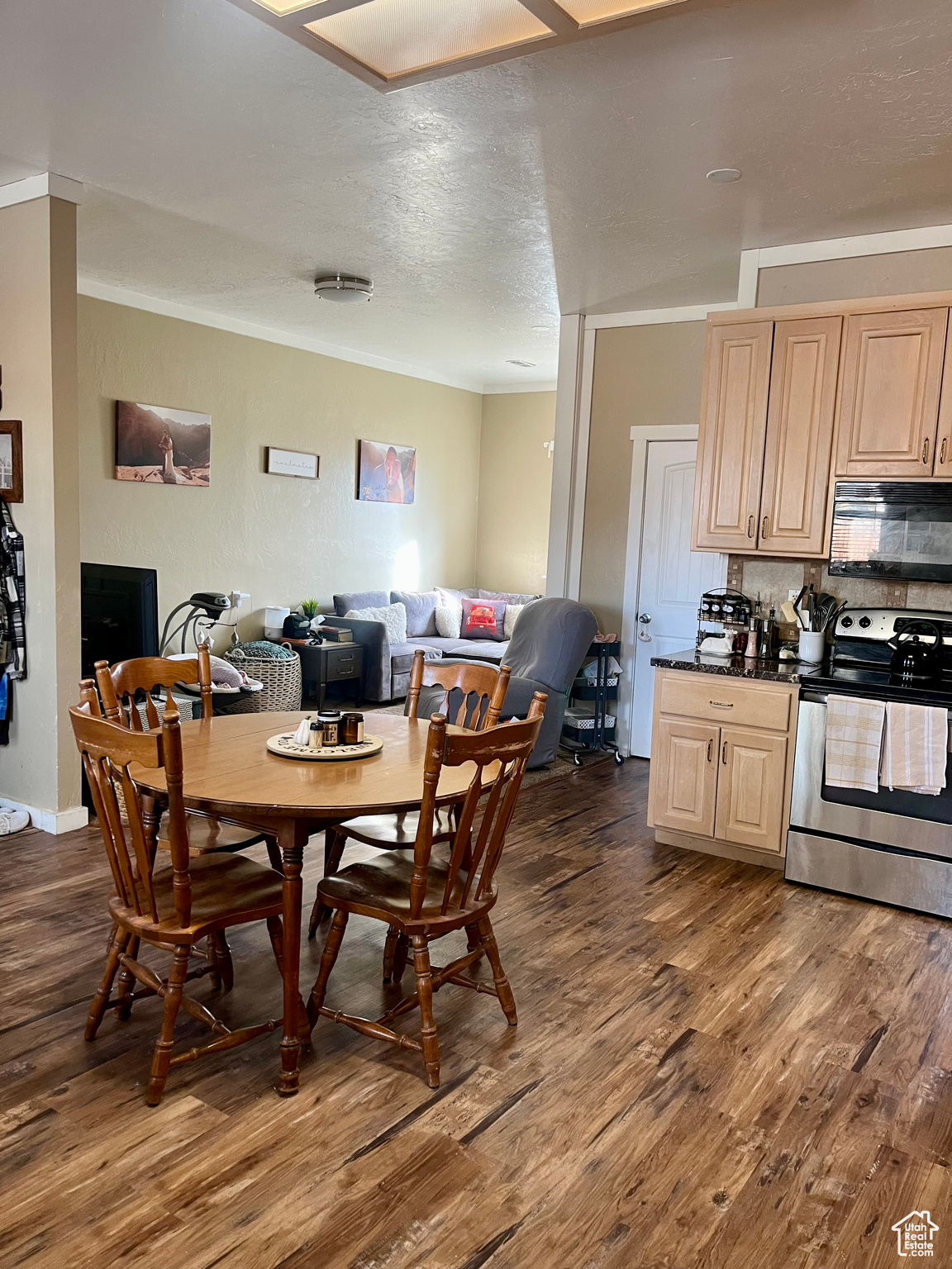 Dining area featuring crown molding, dark wood-type flooring, and a textured ceiling