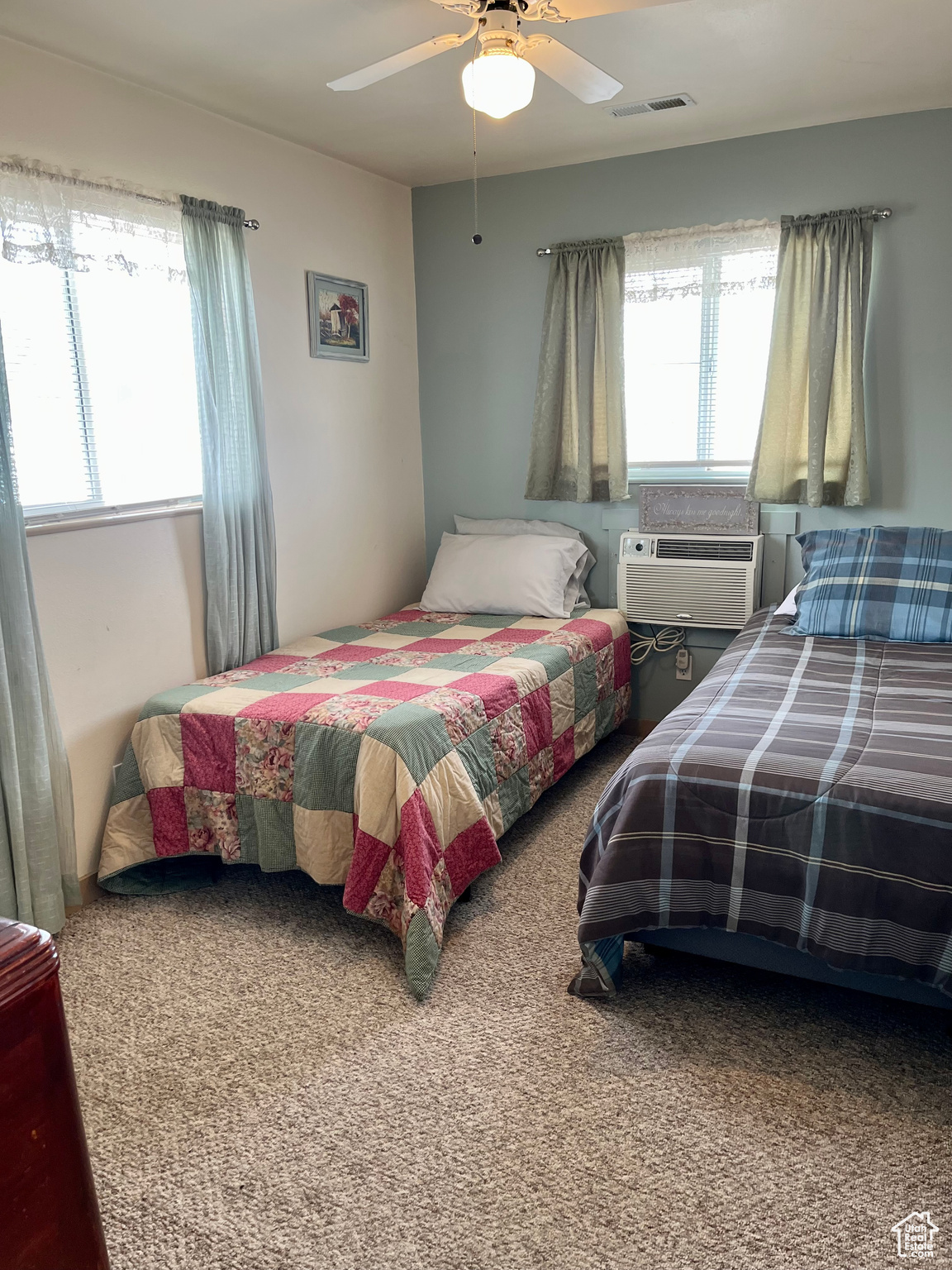 Bedroom featuring ceiling fan, a wall unit AC, and carpet
