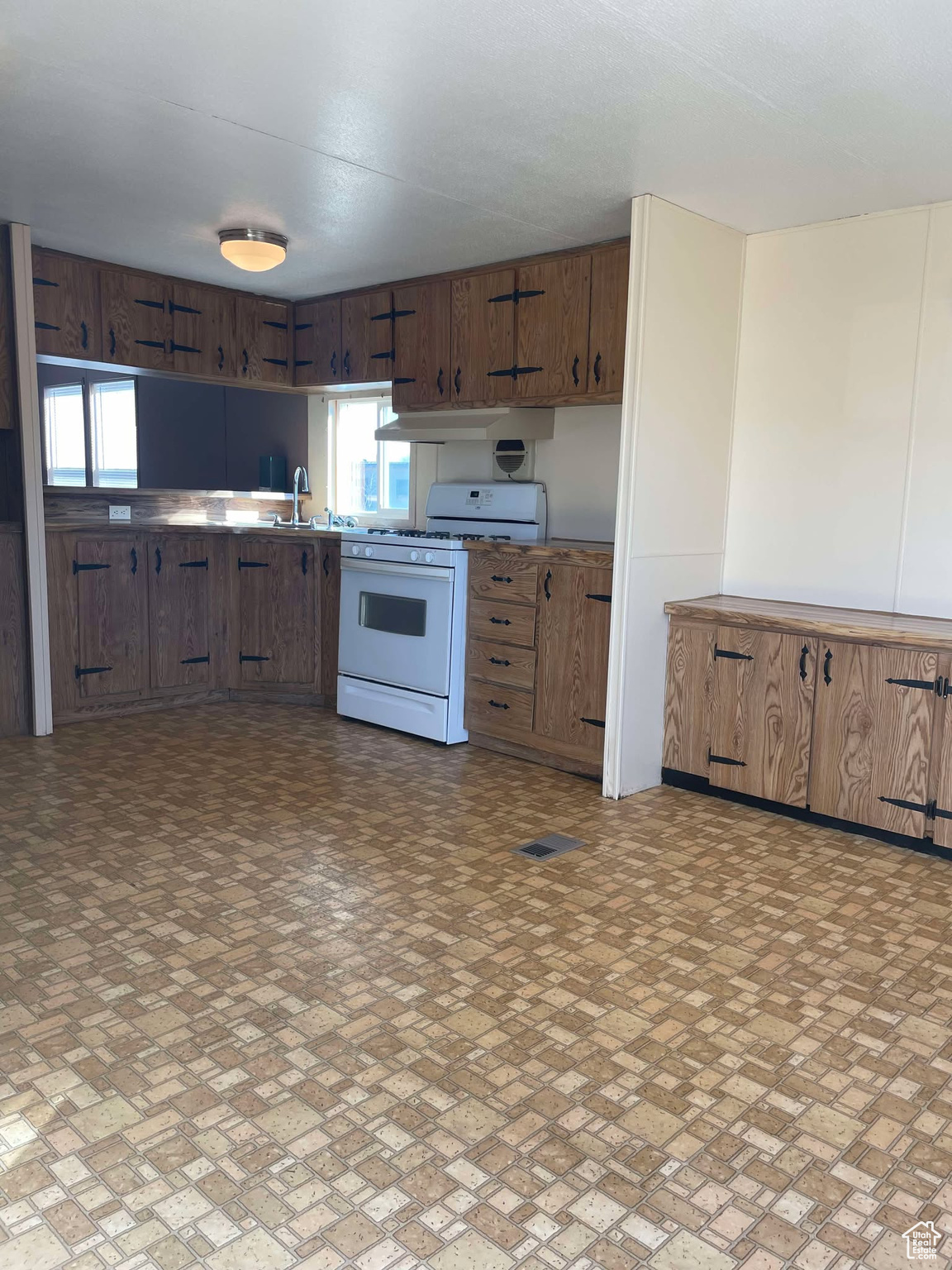 Kitchen featuring a healthy amount of sunlight, sink, and white gas range oven