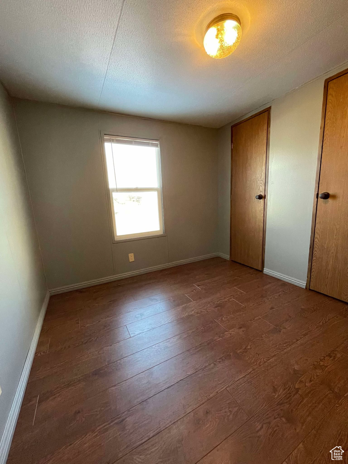 Unfurnished bedroom with hardwood / wood-style floors and a textured ceiling