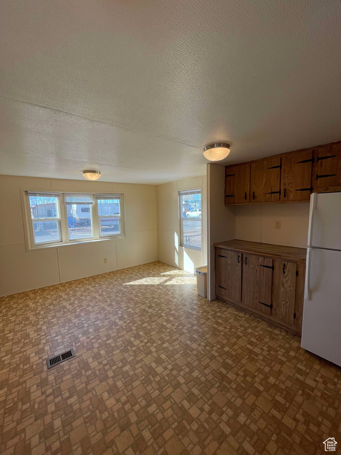 Kitchen with a textured ceiling and white refrigerator