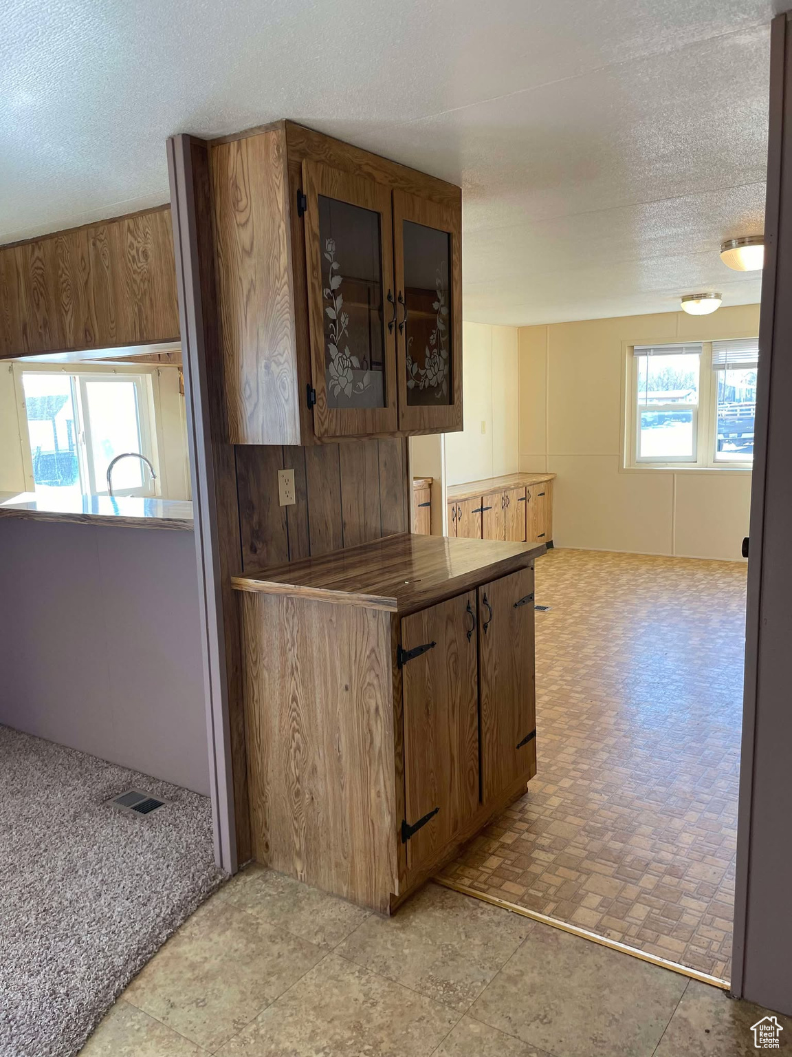 Kitchen with light carpet and a textured ceiling