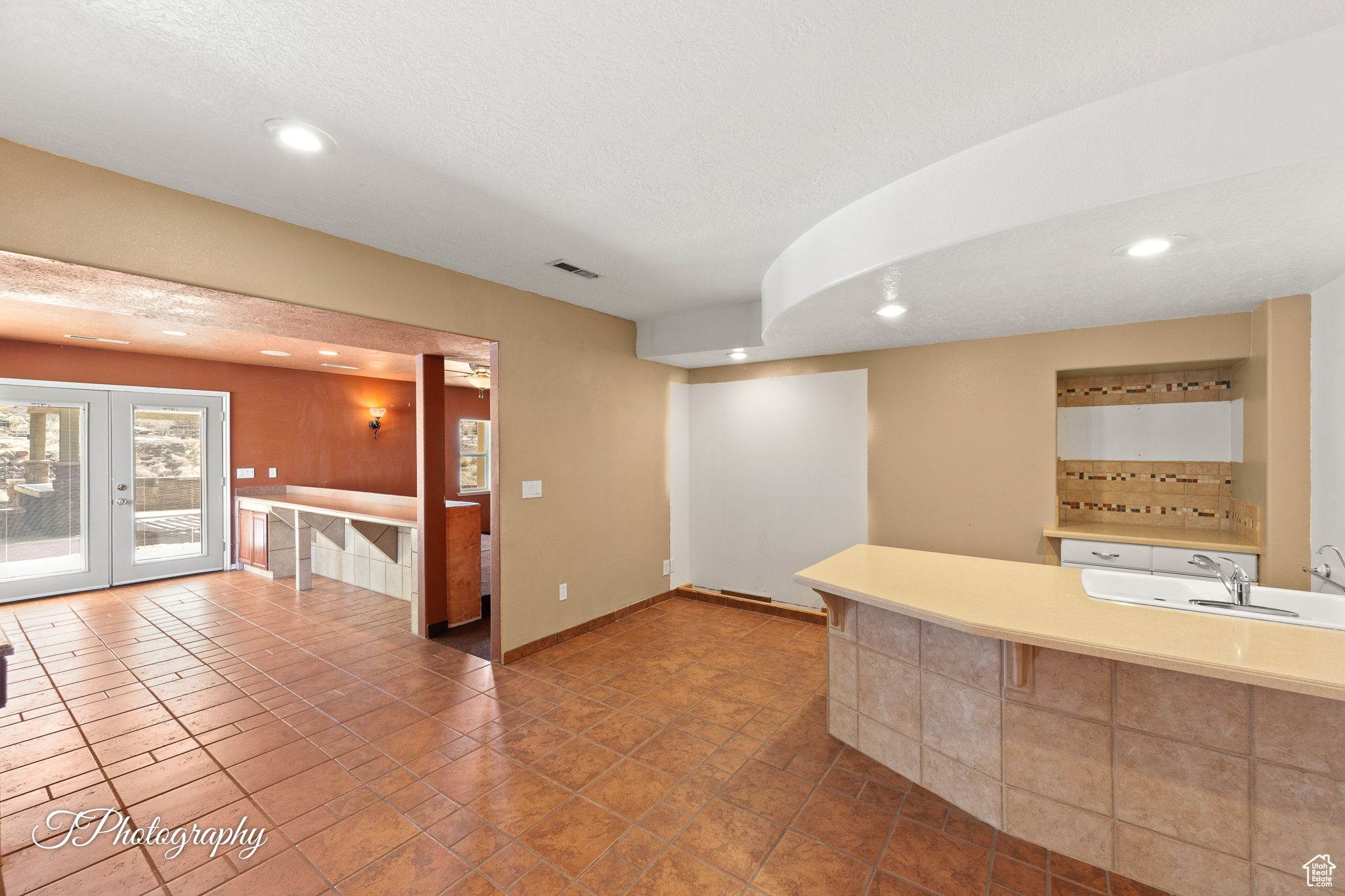 Kitchen featuring french doors, sink, and a textured ceiling