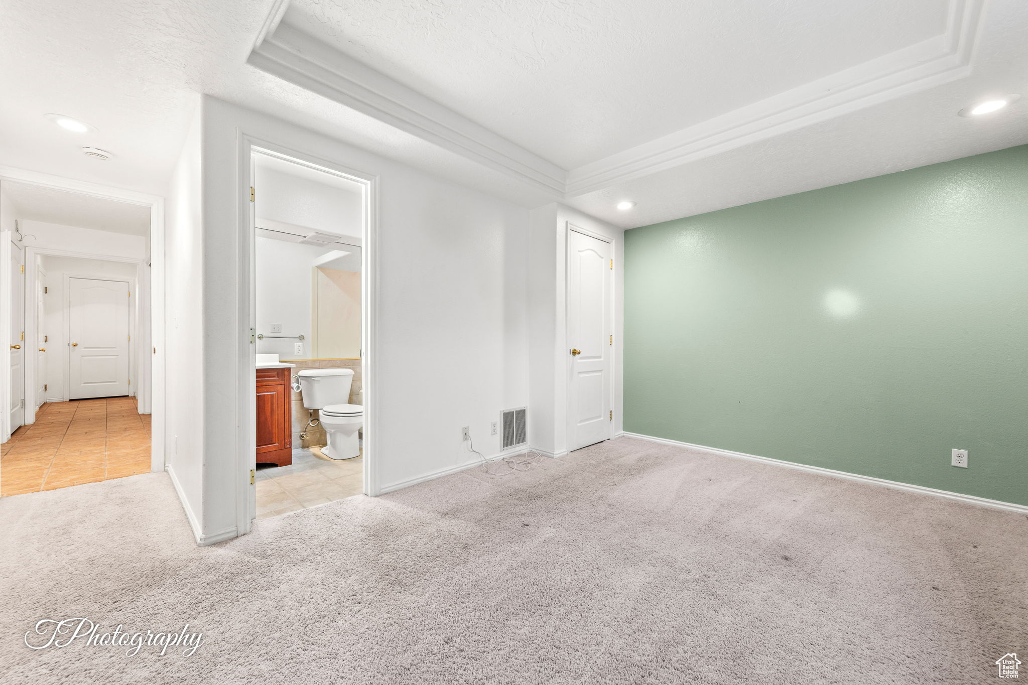Carpeted spare room featuring a tray ceiling