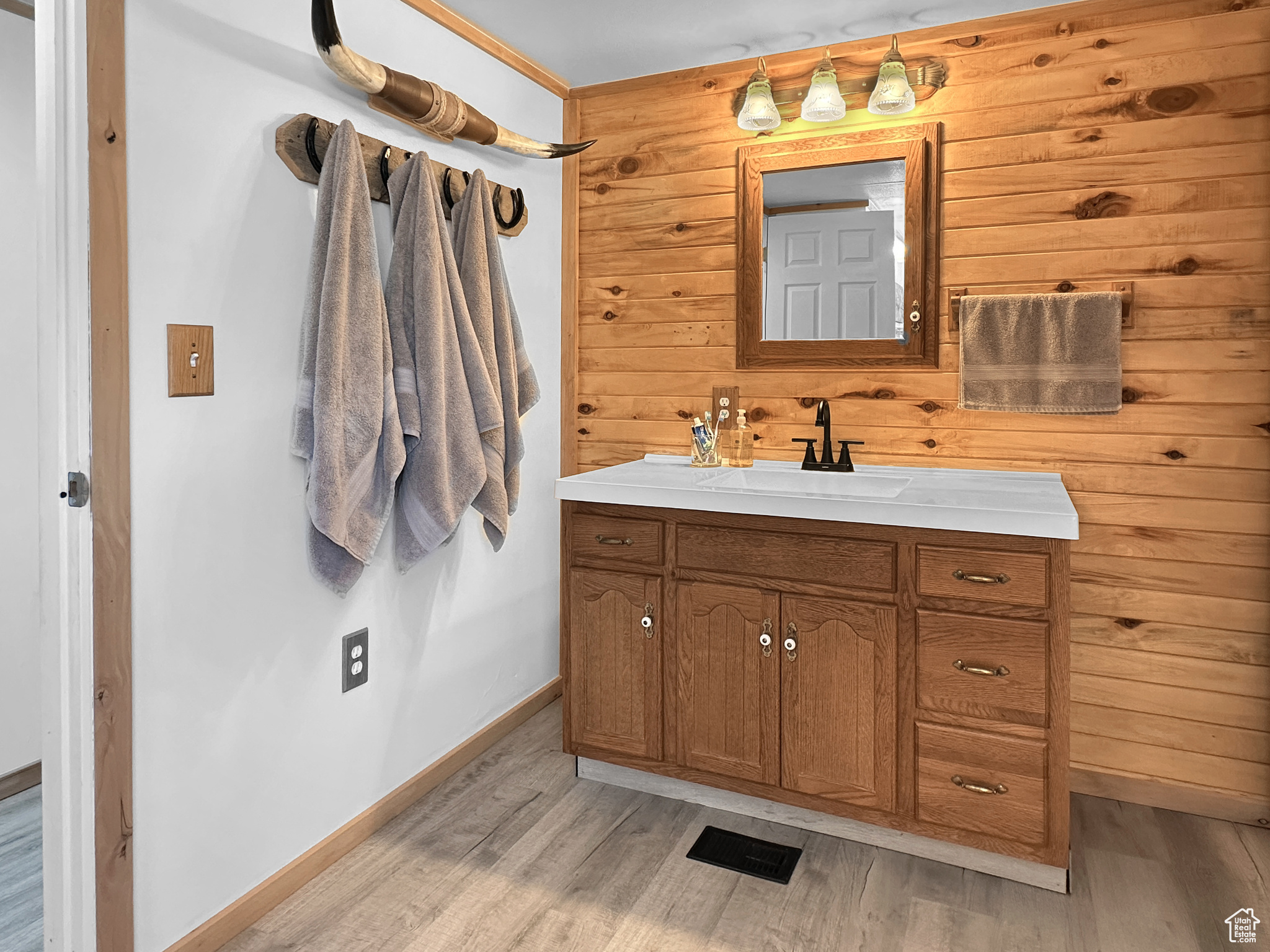 Bathroom featuring vanity, hardwood / wood-style floors, and wood walls
