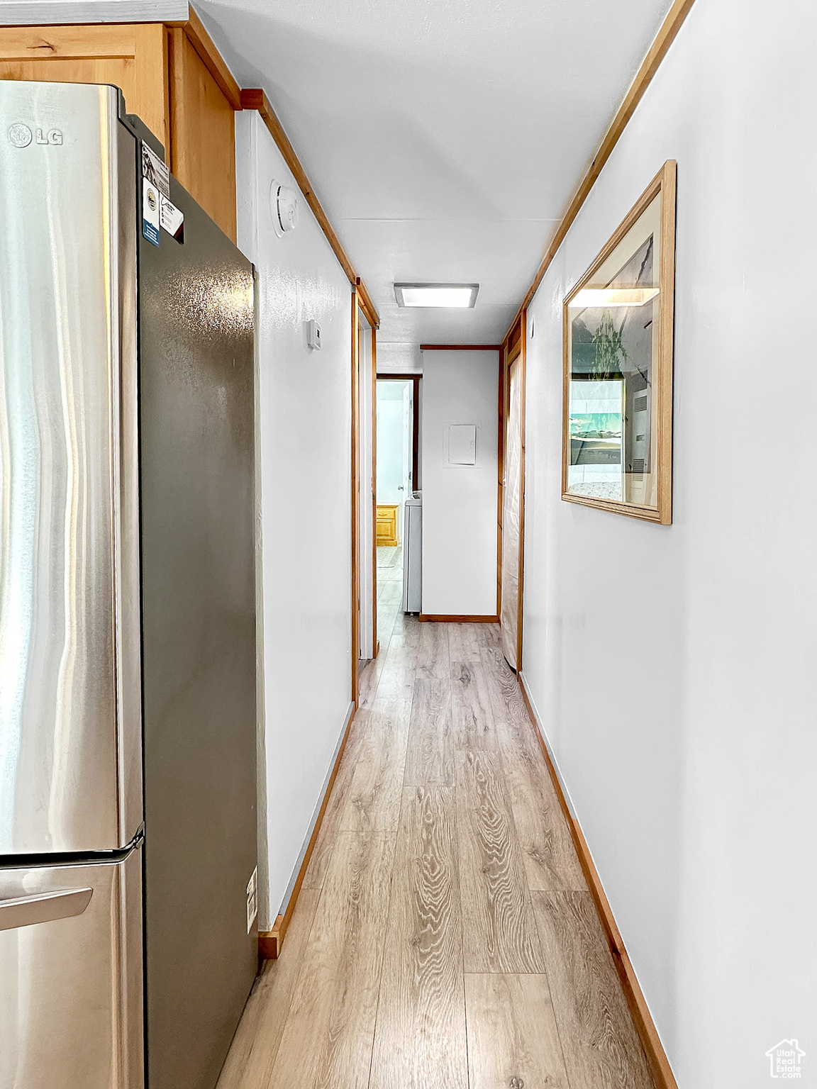 Corridor featuring ornamental molding and light wood-type flooring
