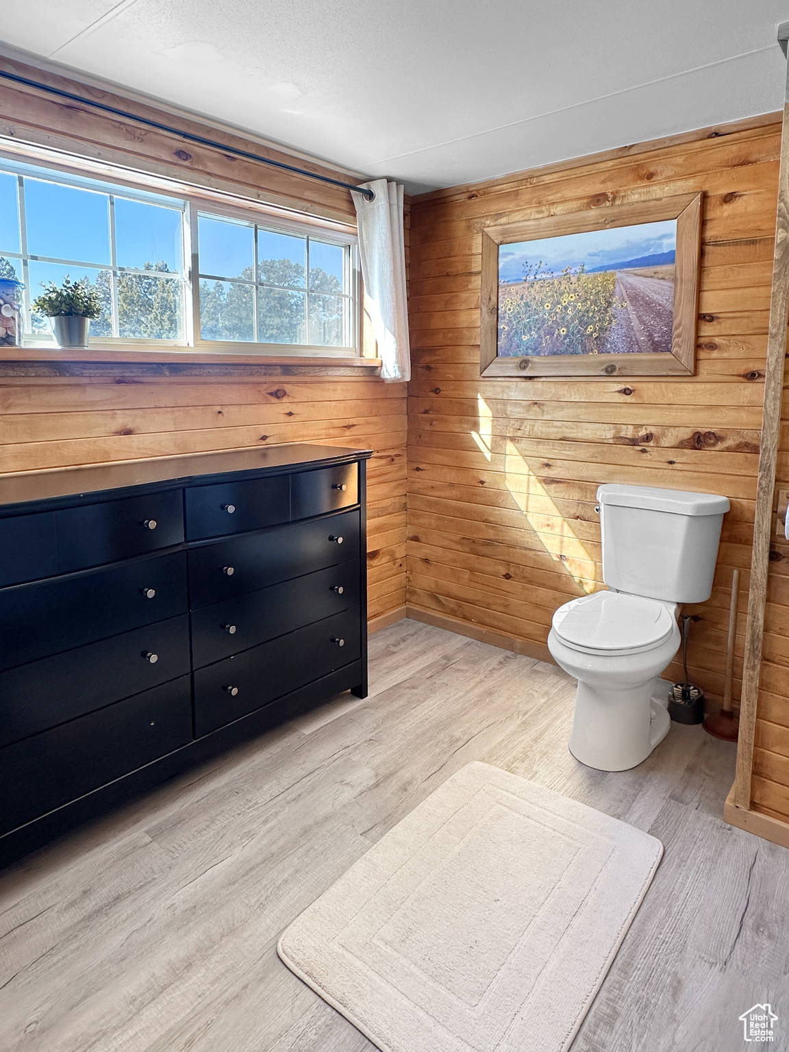 Bathroom featuring vanity, wood-type flooring, toilet, and wood walls