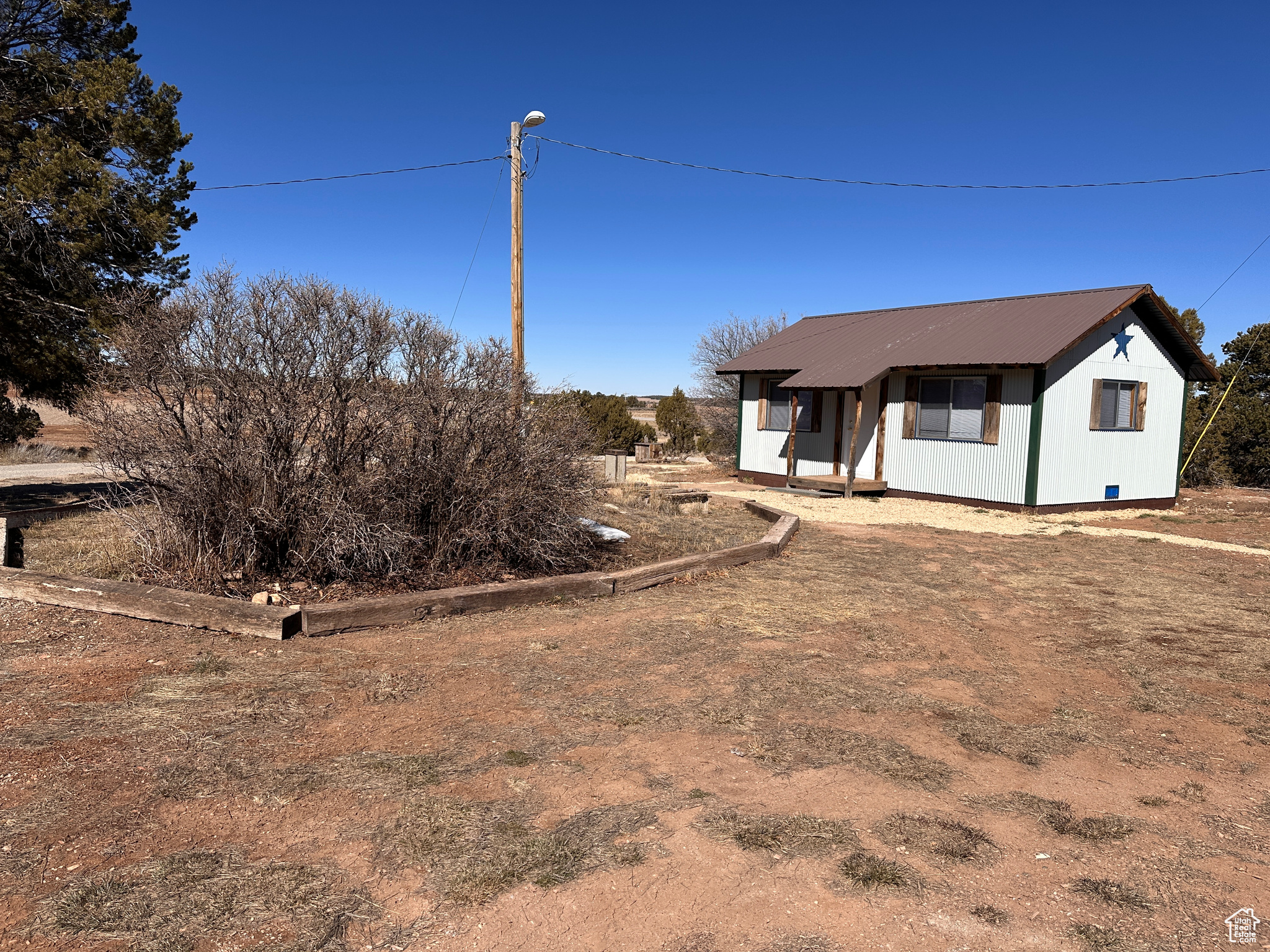 View of front of property featuring metal roof and crawl space