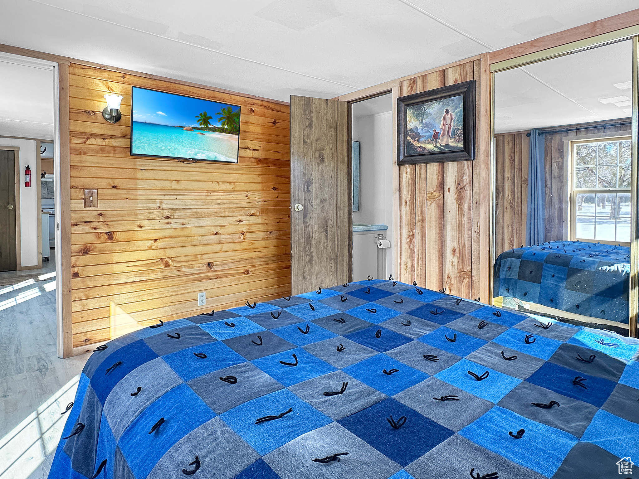 Unfurnished bedroom featuring wood-type flooring and wood walls