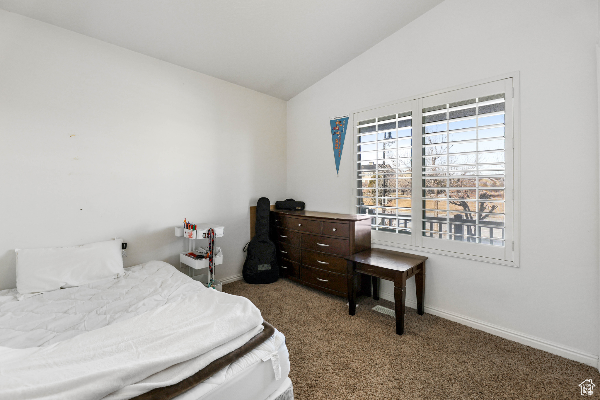 Bedroom with vaulted ceiling and carpet flooring