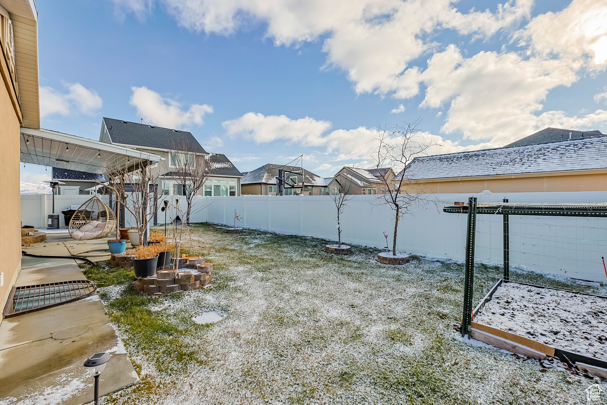 Yard layered in snow featuring a patio area