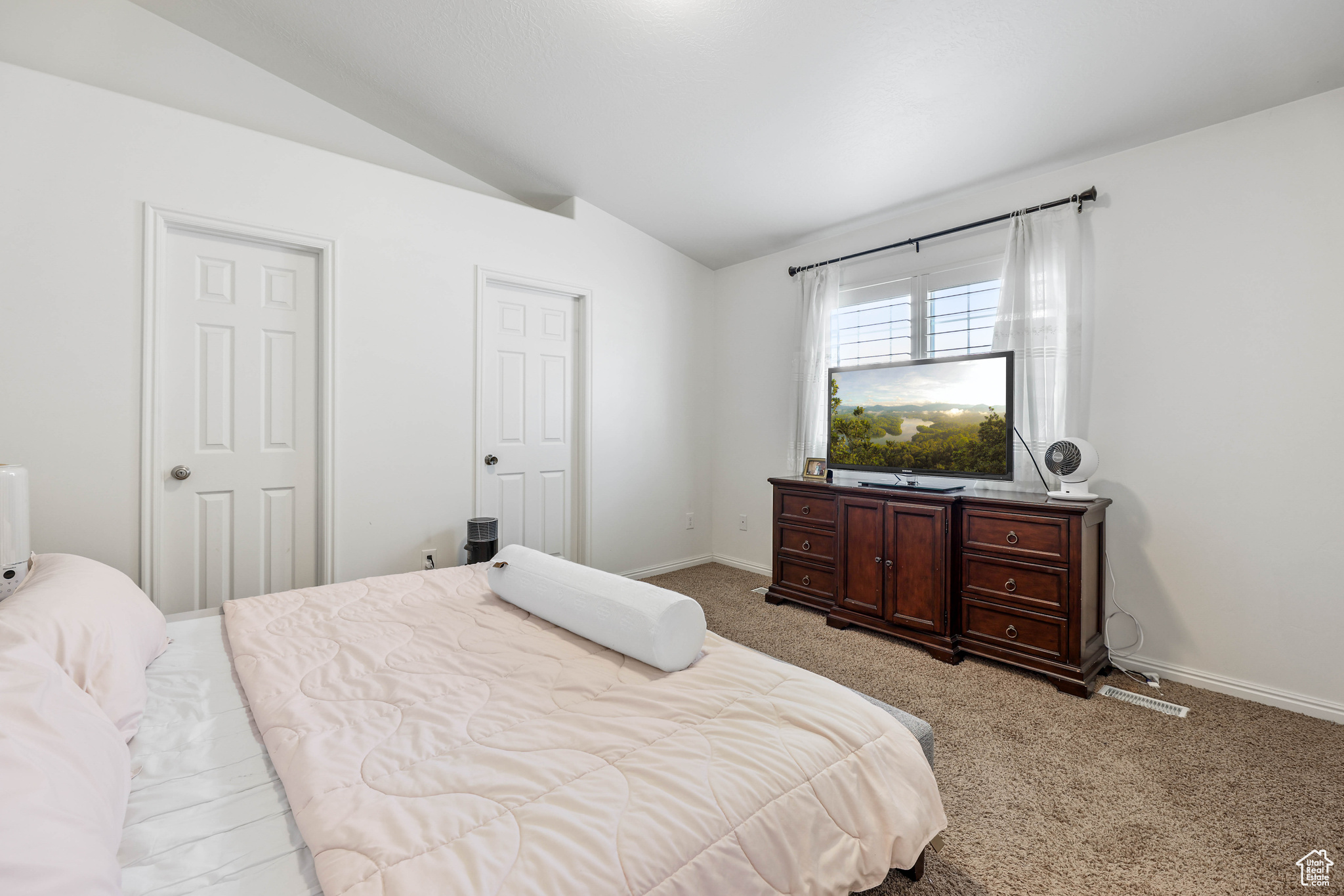 Bedroom featuring light colored carpet and lofted ceiling