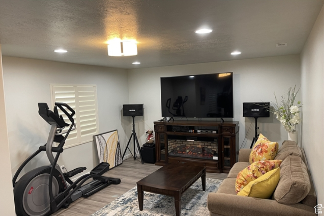 Workout room featuring light hardwood / wood-style floors and a textured ceiling