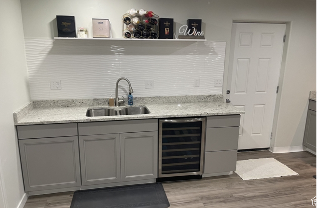 Bar with wine cooler, sink, and gray cabinetry
