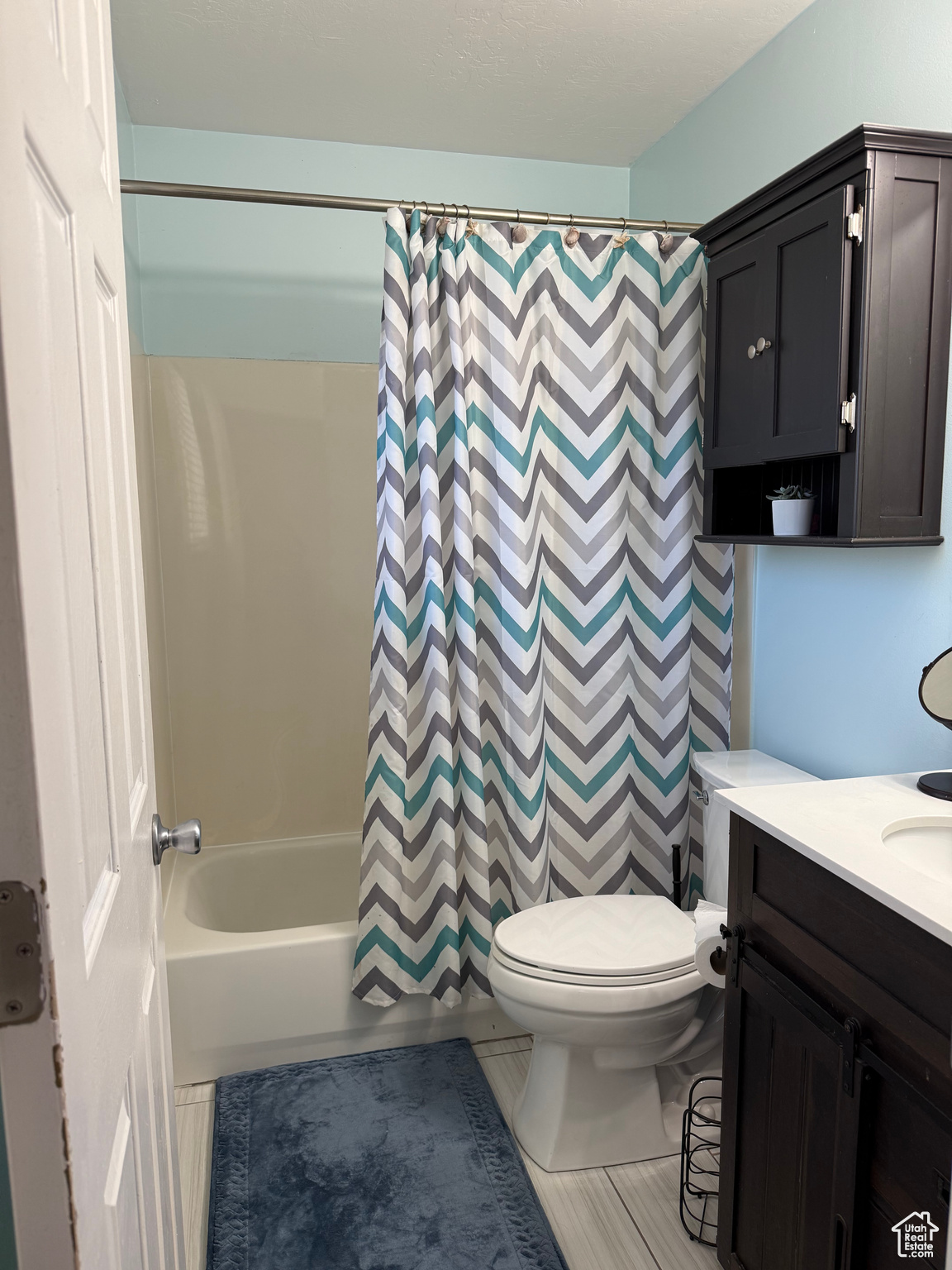 Full bathroom featuring shower / tub combo with curtain, vanity, and toilet