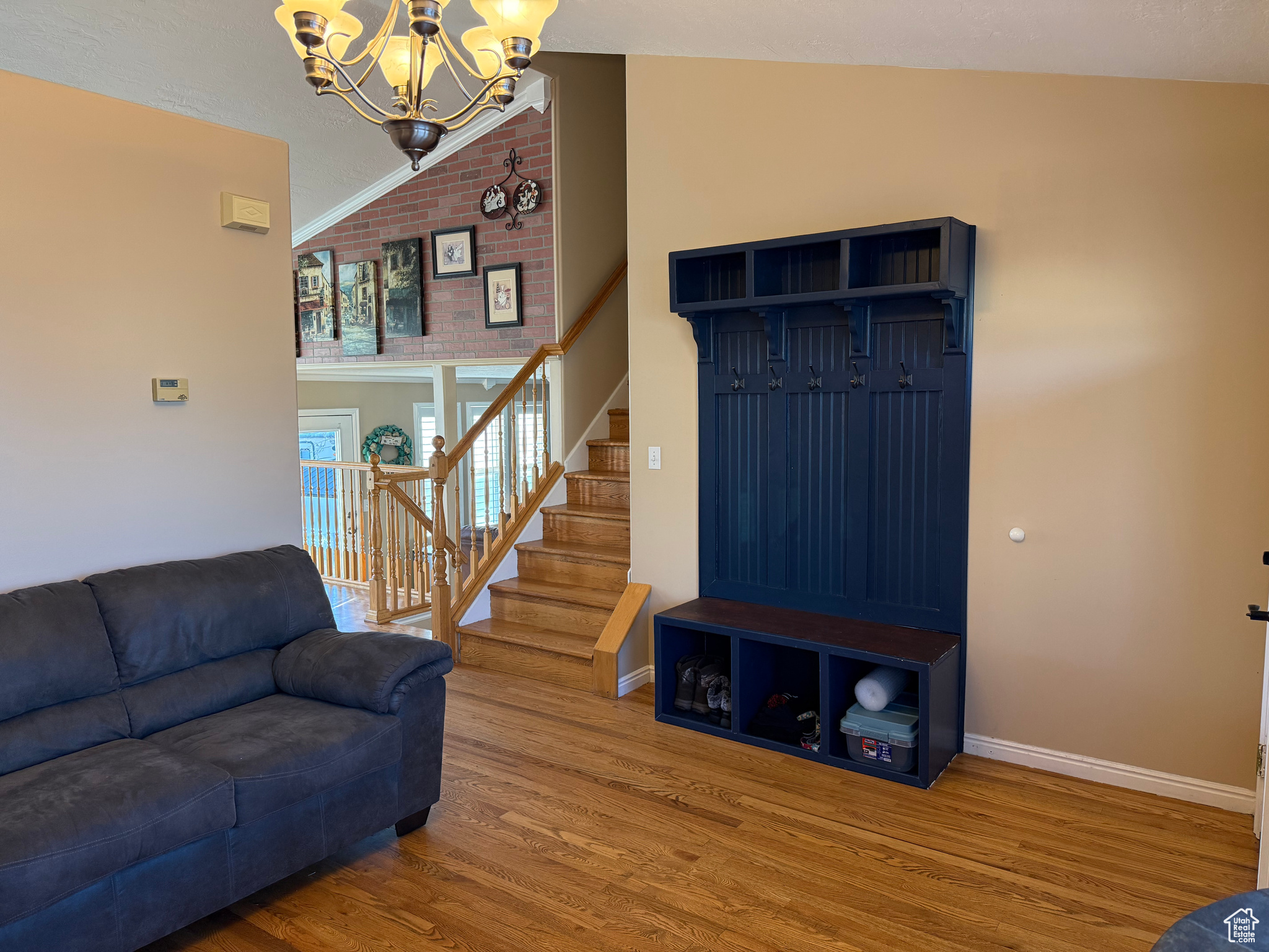 Interior space with lofted ceiling, a chandelier, and hardwood / hardwood floors