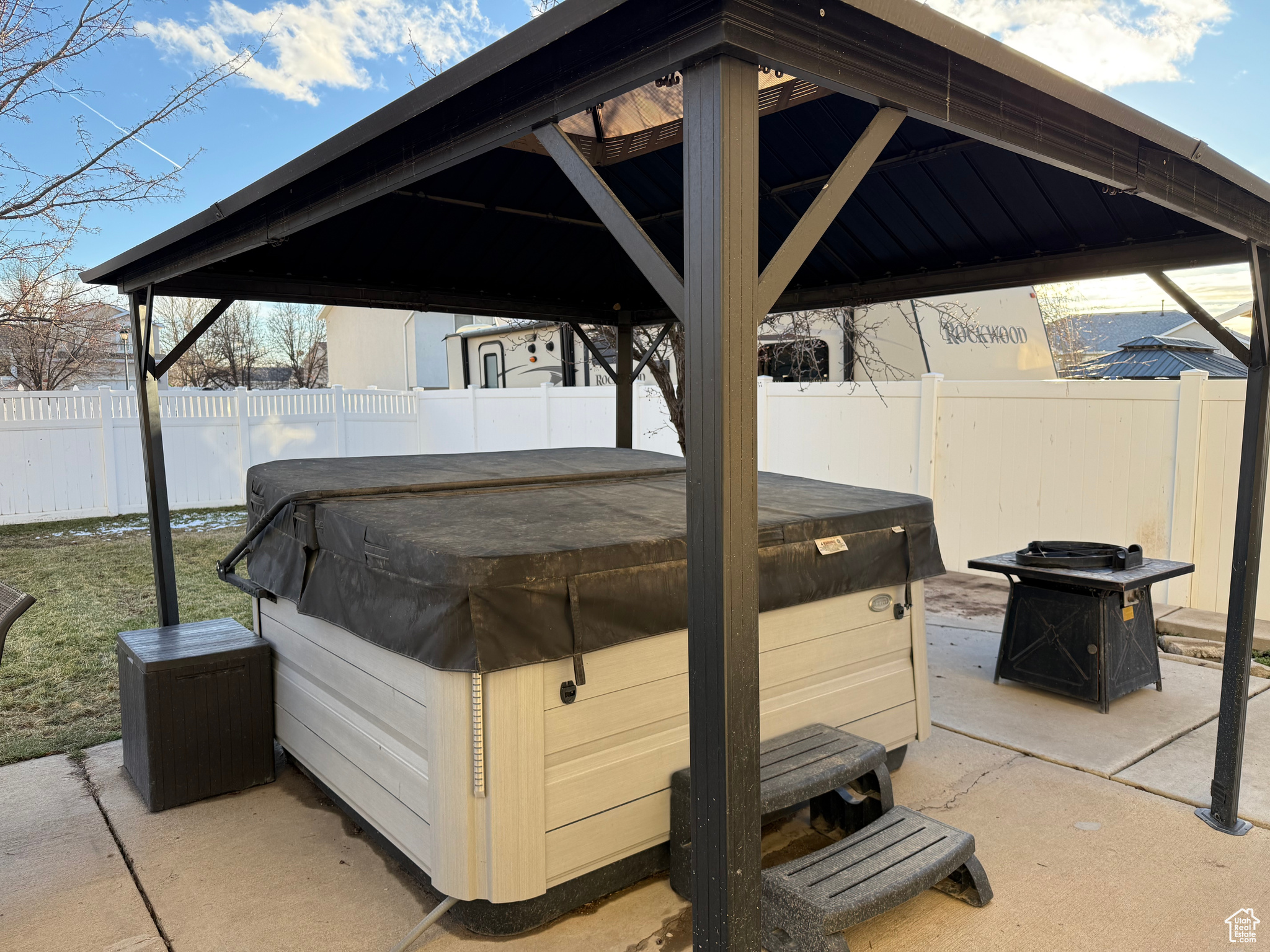 View of patio featuring a hot tub and a gazebo