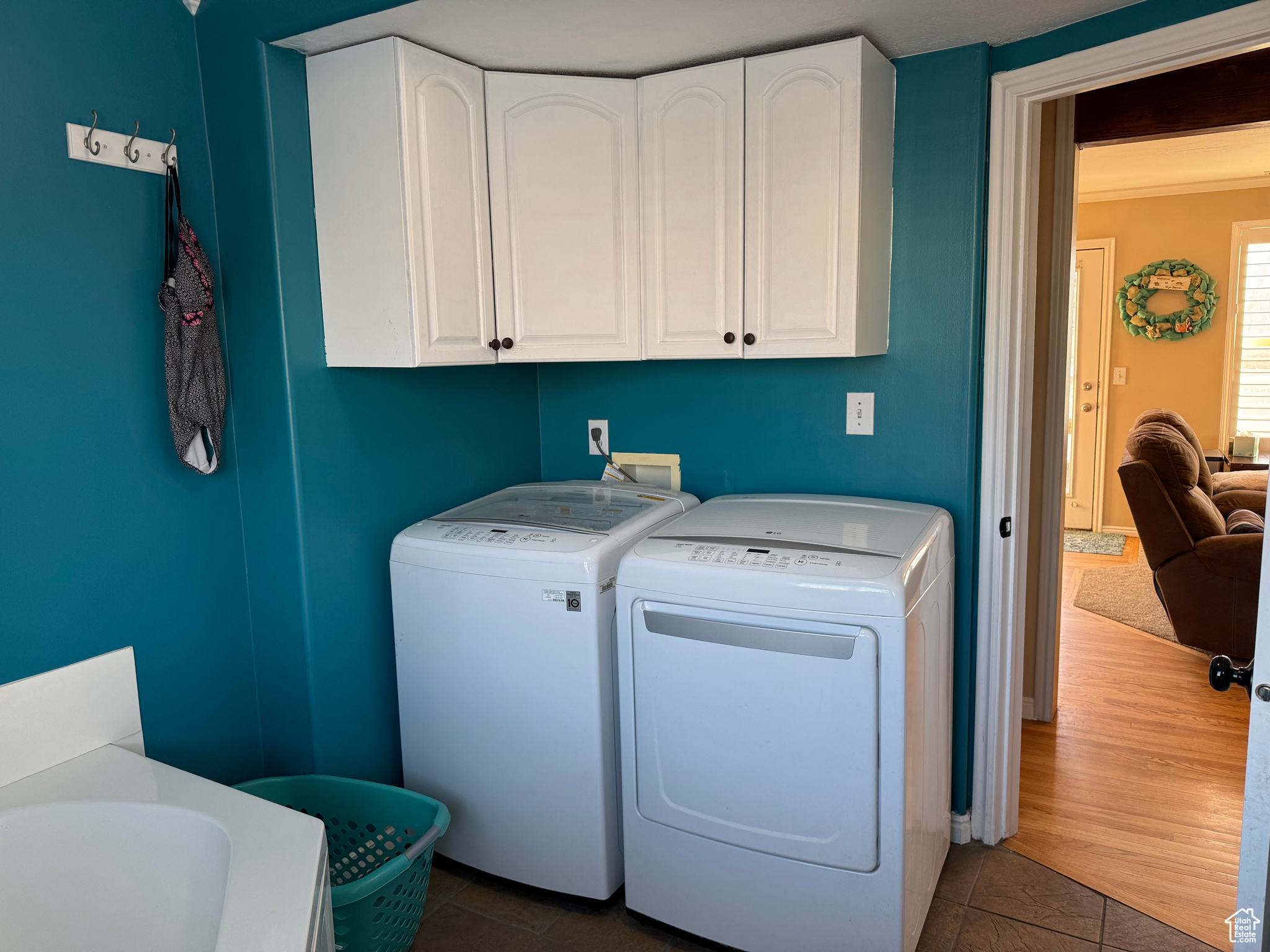 Laundry room with cabinets, washer and dryer, and dark tile patterned floors