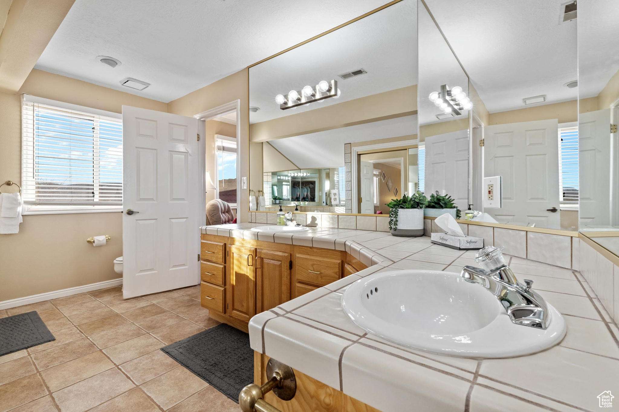 Bathroom featuring vanity, toilet, and tile patterned flooring
