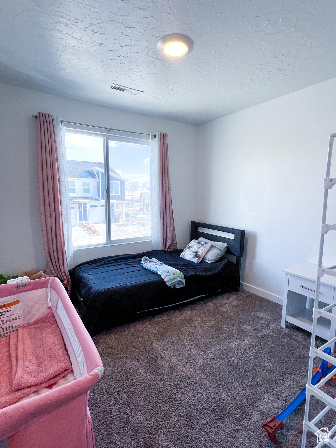 Carpeted bedroom with a textured ceiling