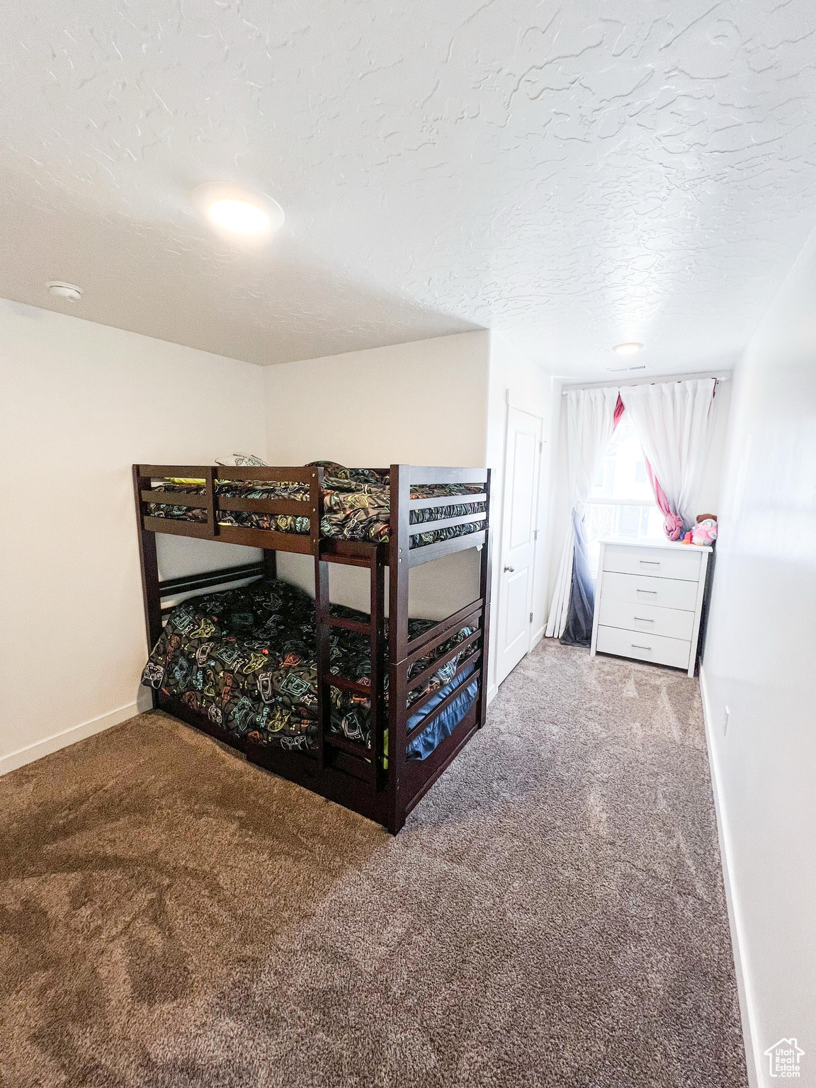 Carpeted bedroom with a textured ceiling